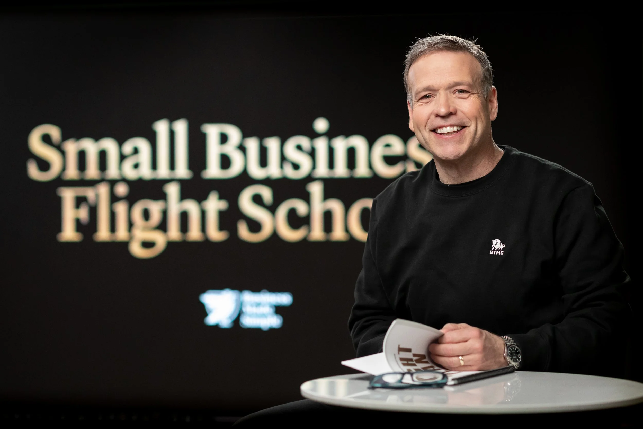 Business mentor seated at a table during a Small Business Flight School session, representing guidance and strategic mentorship for small business owners.