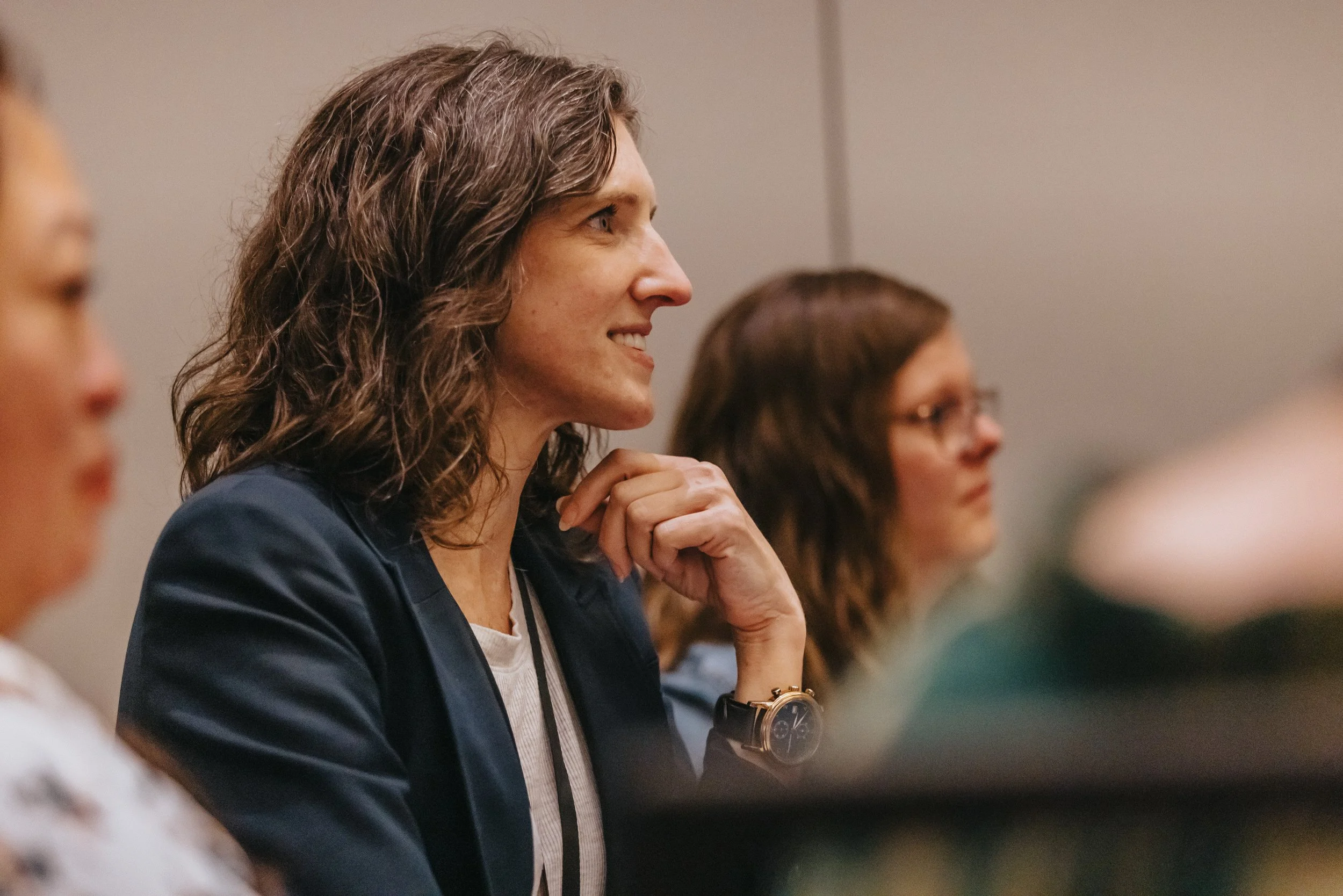 Alt text: Annie Figenshu listening during a StoryBrand event where Donald Miller discussed the Certified Guide title change.