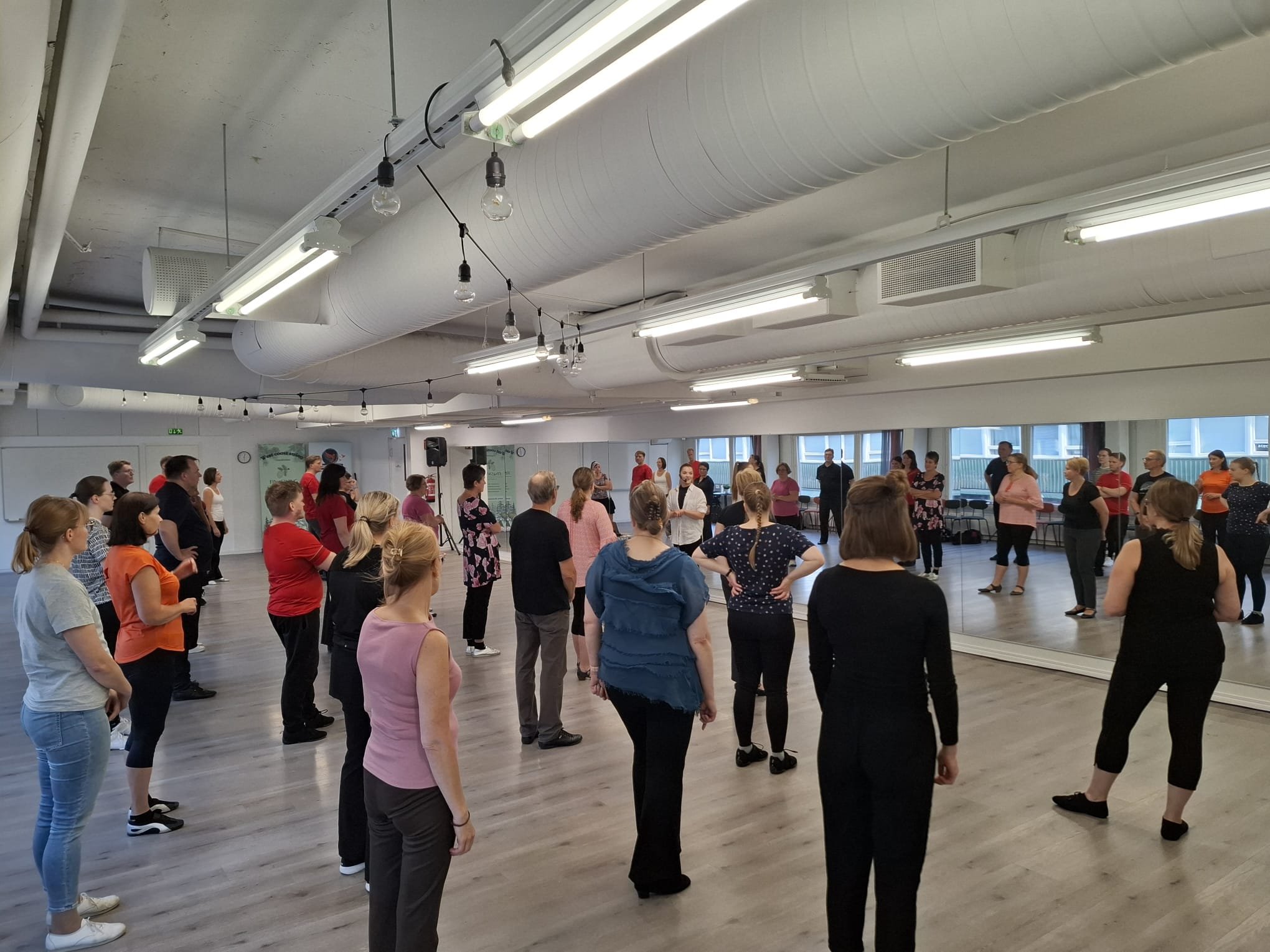 Ryhmäläisiä tanssitunnilla peilin edessä sisätiloissa.