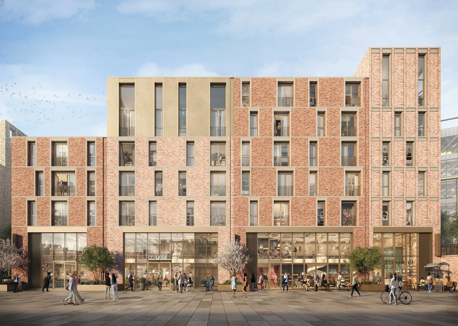Modern multi-story building with retail shops on the ground floor and apartments above, people walking and cycling in front, trees and clear sky.