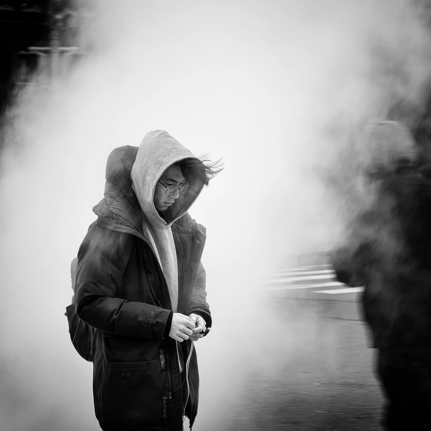 Image of a young man walking through the steam rising from the street — NYC