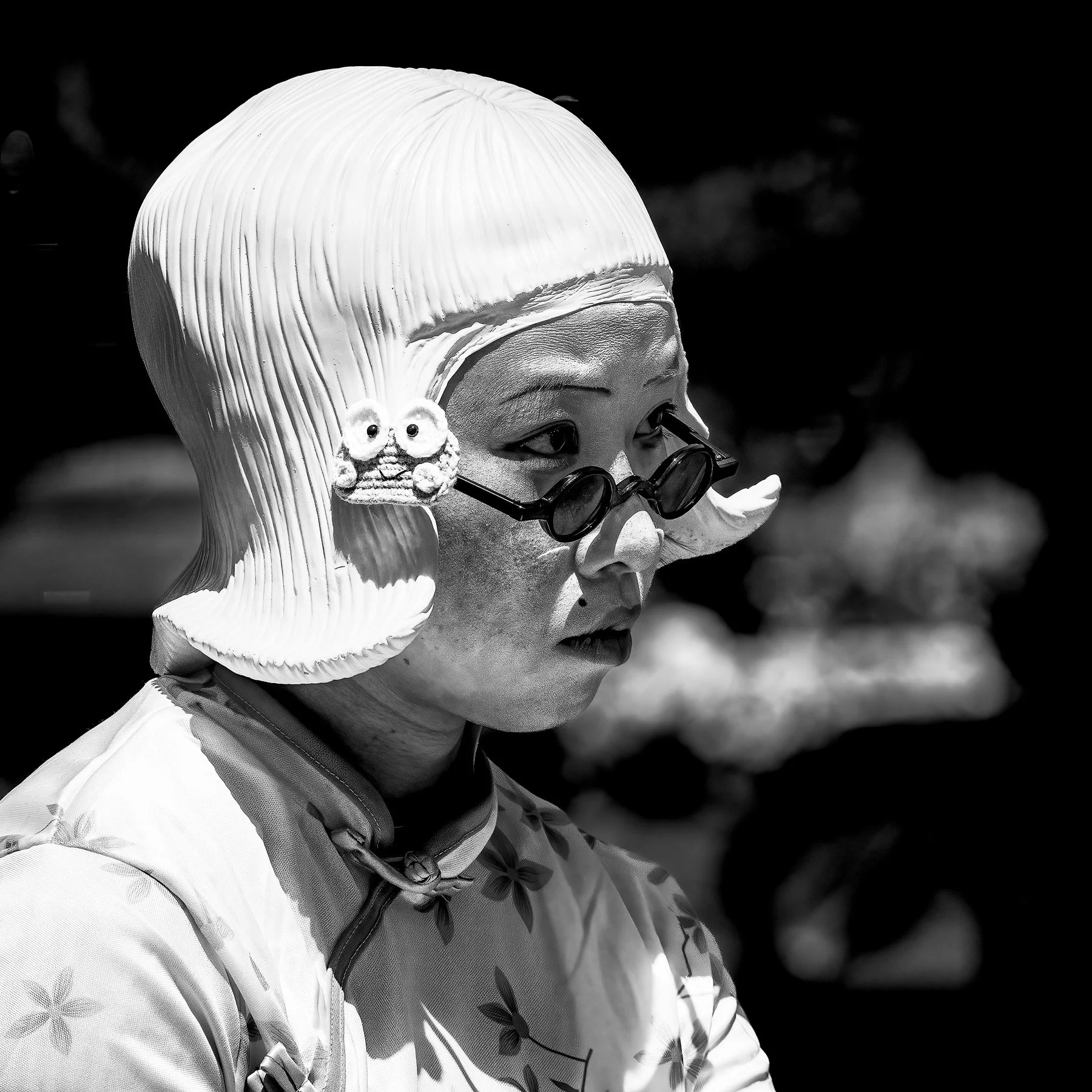 Detail of a woman wearing a rubber wig of 1920's style blond hair — NYC.