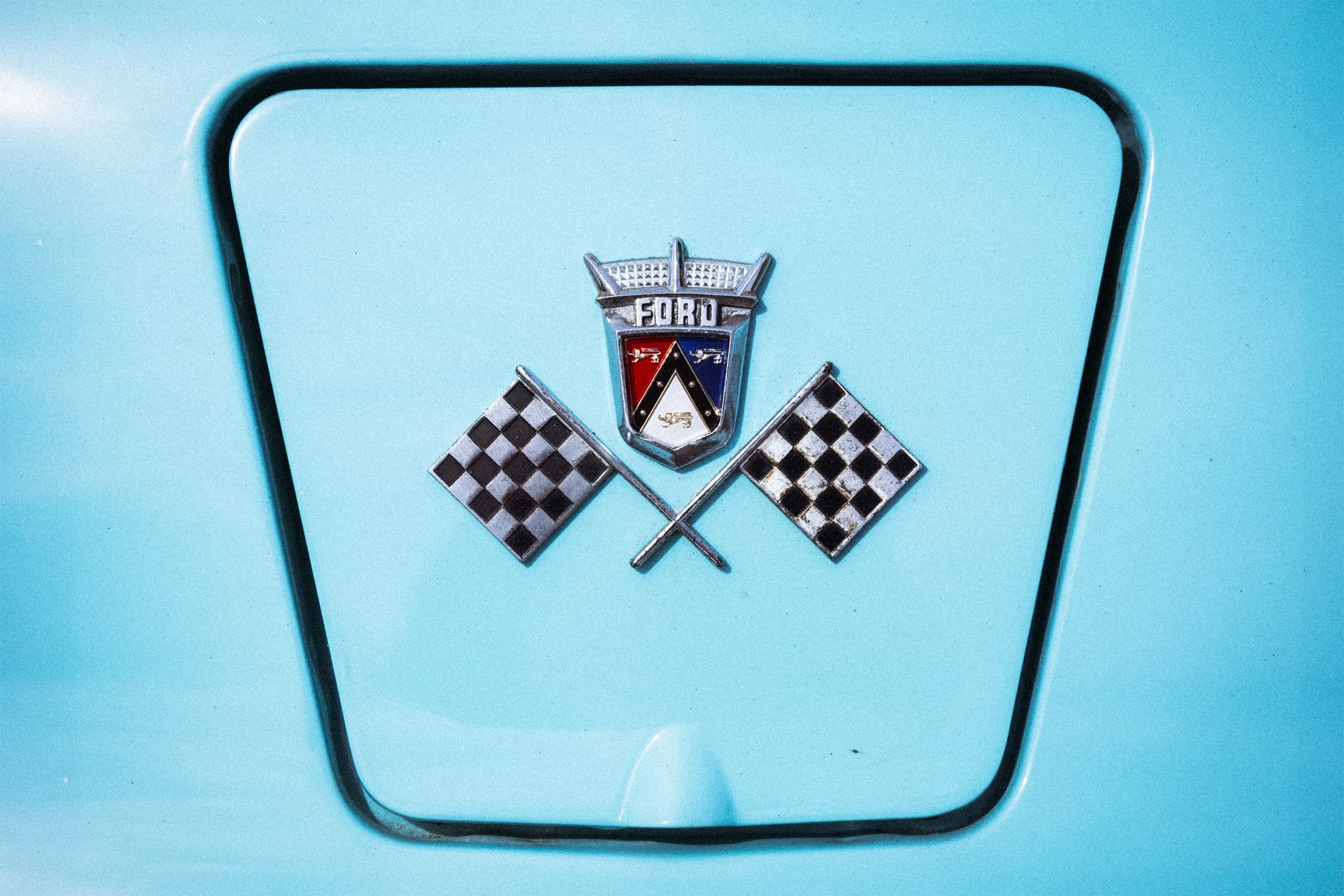 Image of a Ford crossed checkered flag emblem on a gas cap door