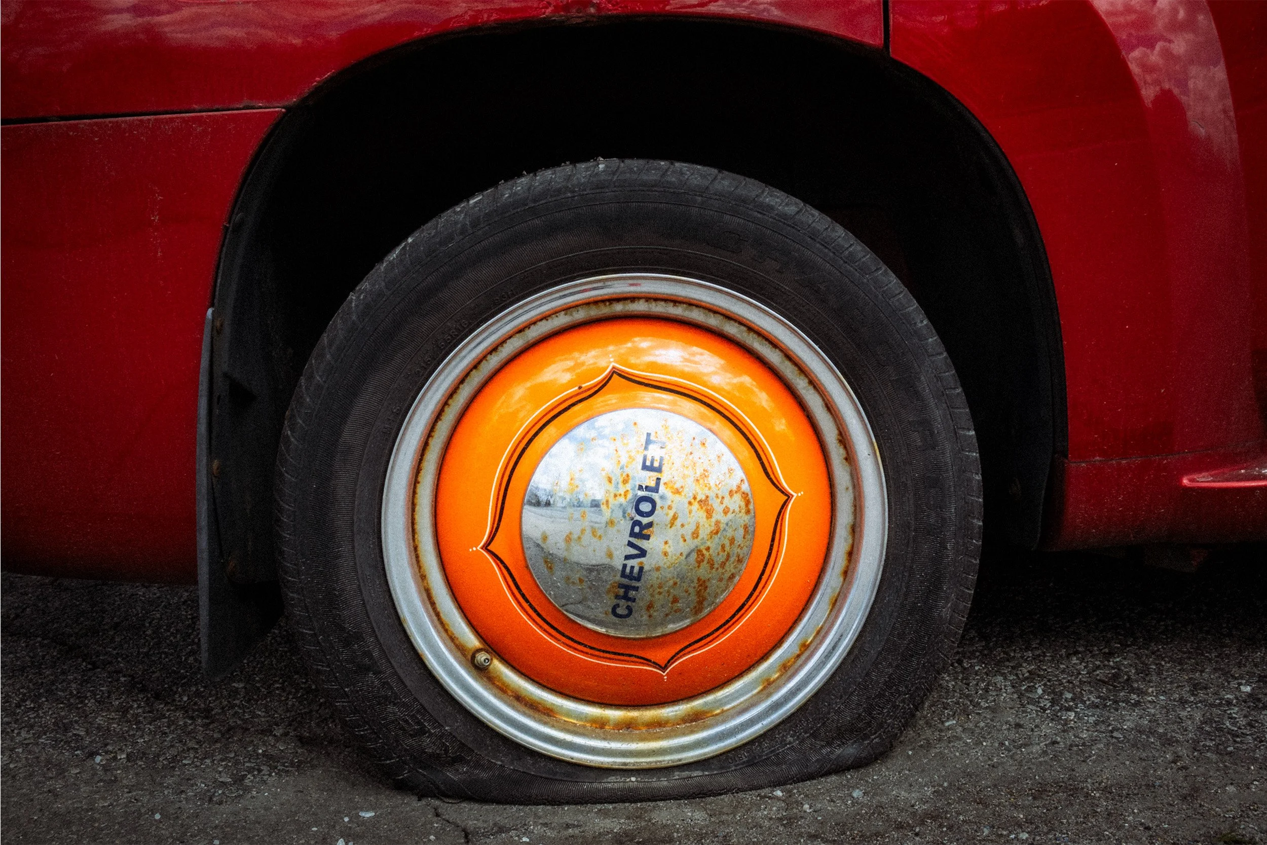Image of an orange and chrome hub cap from a Chevy pick-up truck