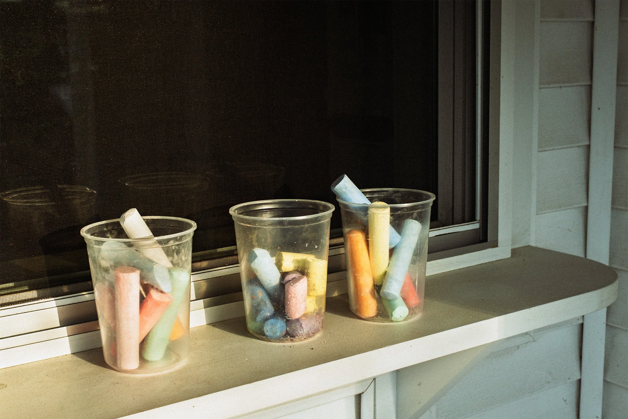 Image of three plastic cups full on colored chalk sticks
