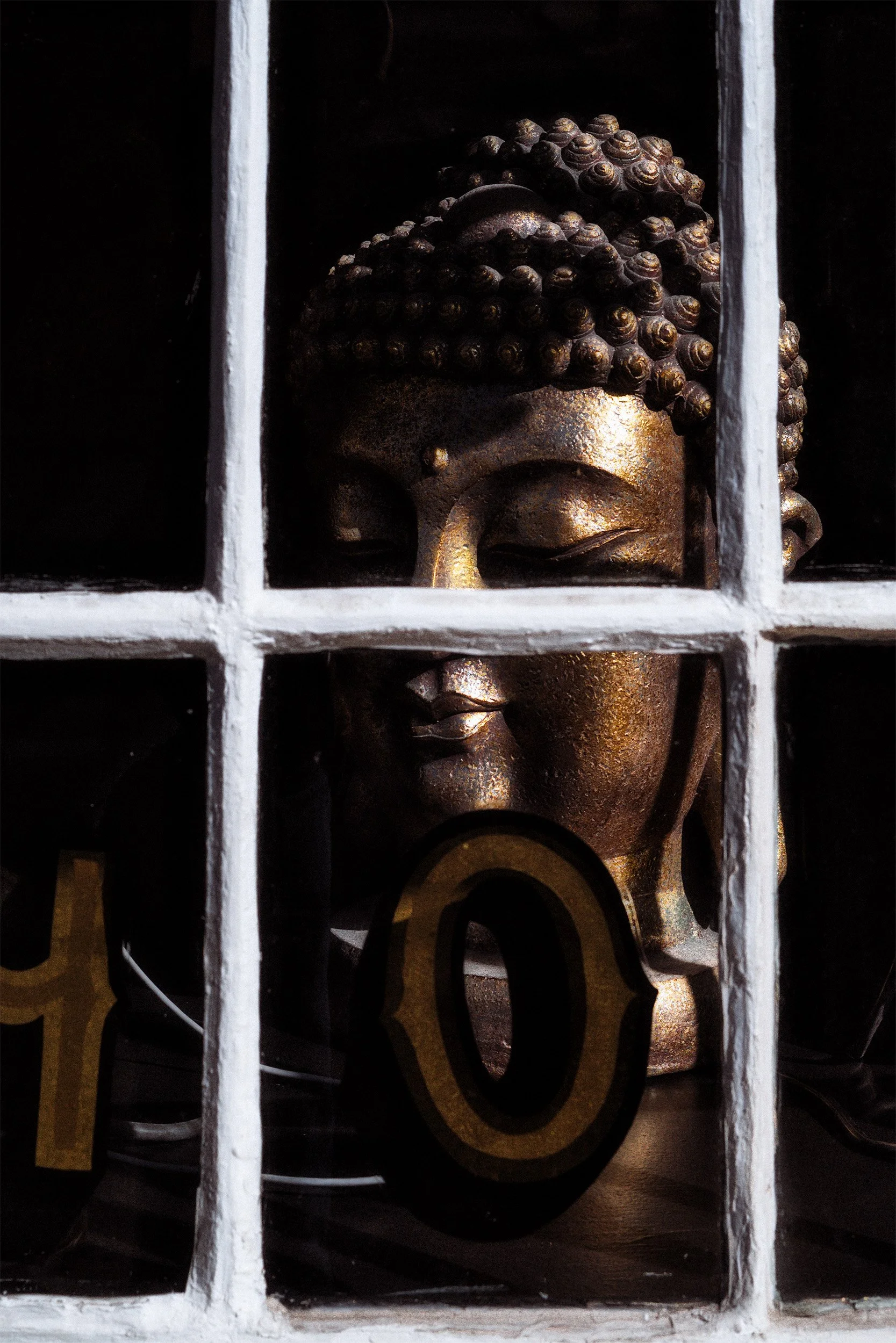 Image of a golden Buddha statue in a store window