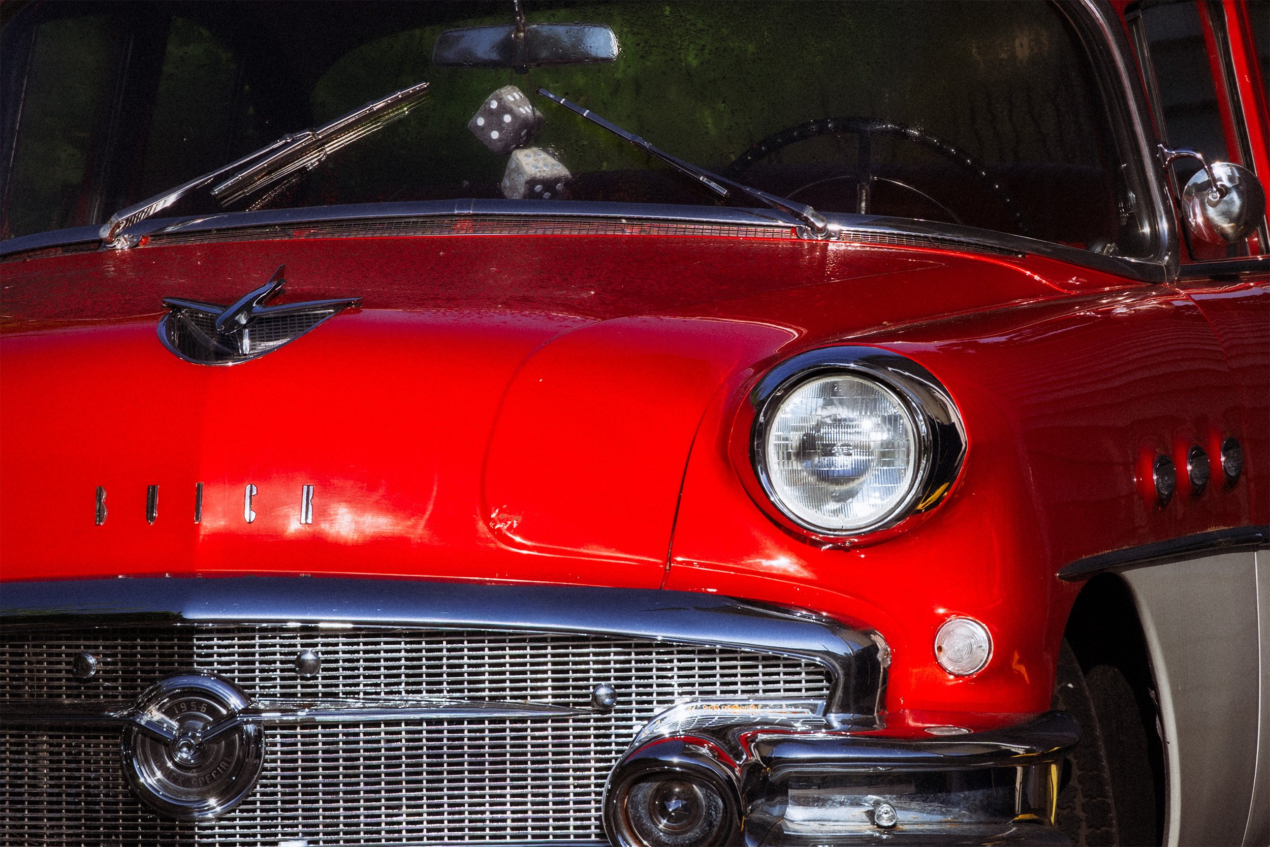 Image of a red and white Buick with black fuzzy dice
