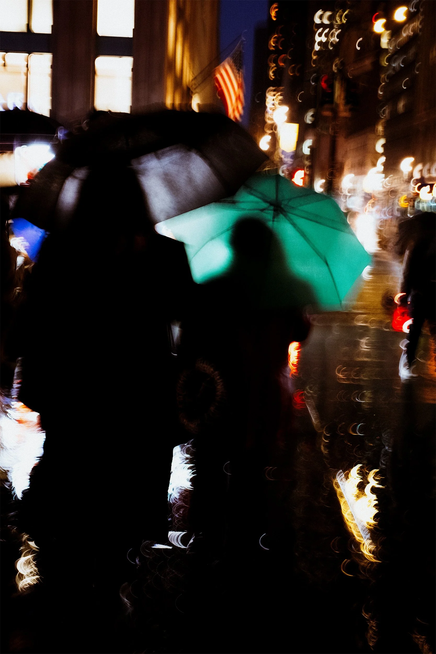 Image of pedestrians walking in the rain with umbrellas in NYC