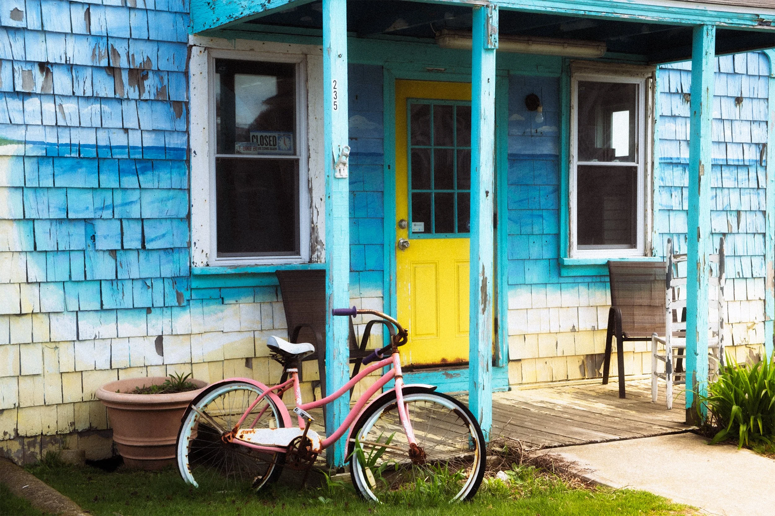 Image of a pink cruiser bike in in front of an old shingled shack