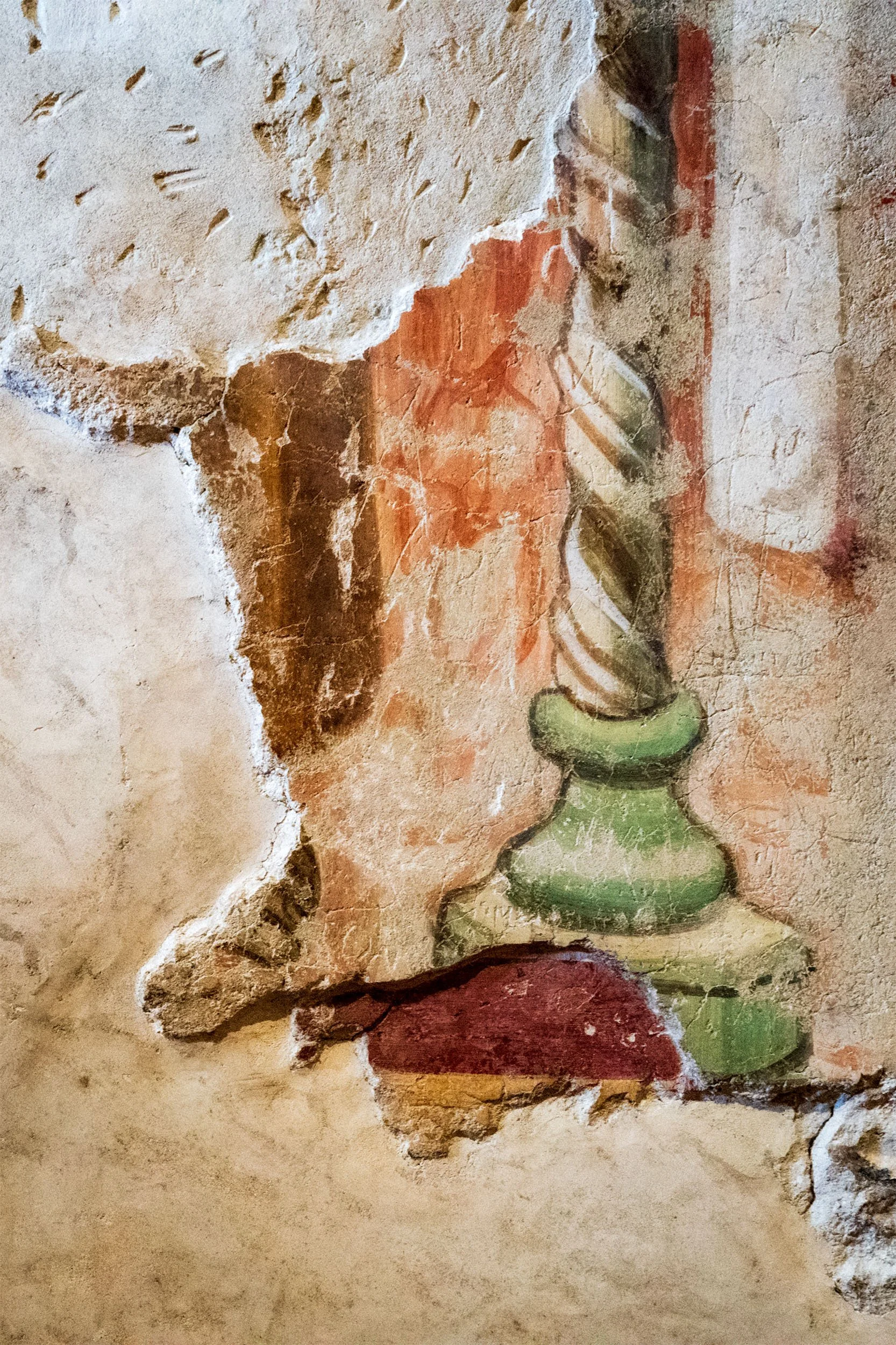 Image of a stucco painting of a candlestick on a wall in Assisi, Italy.