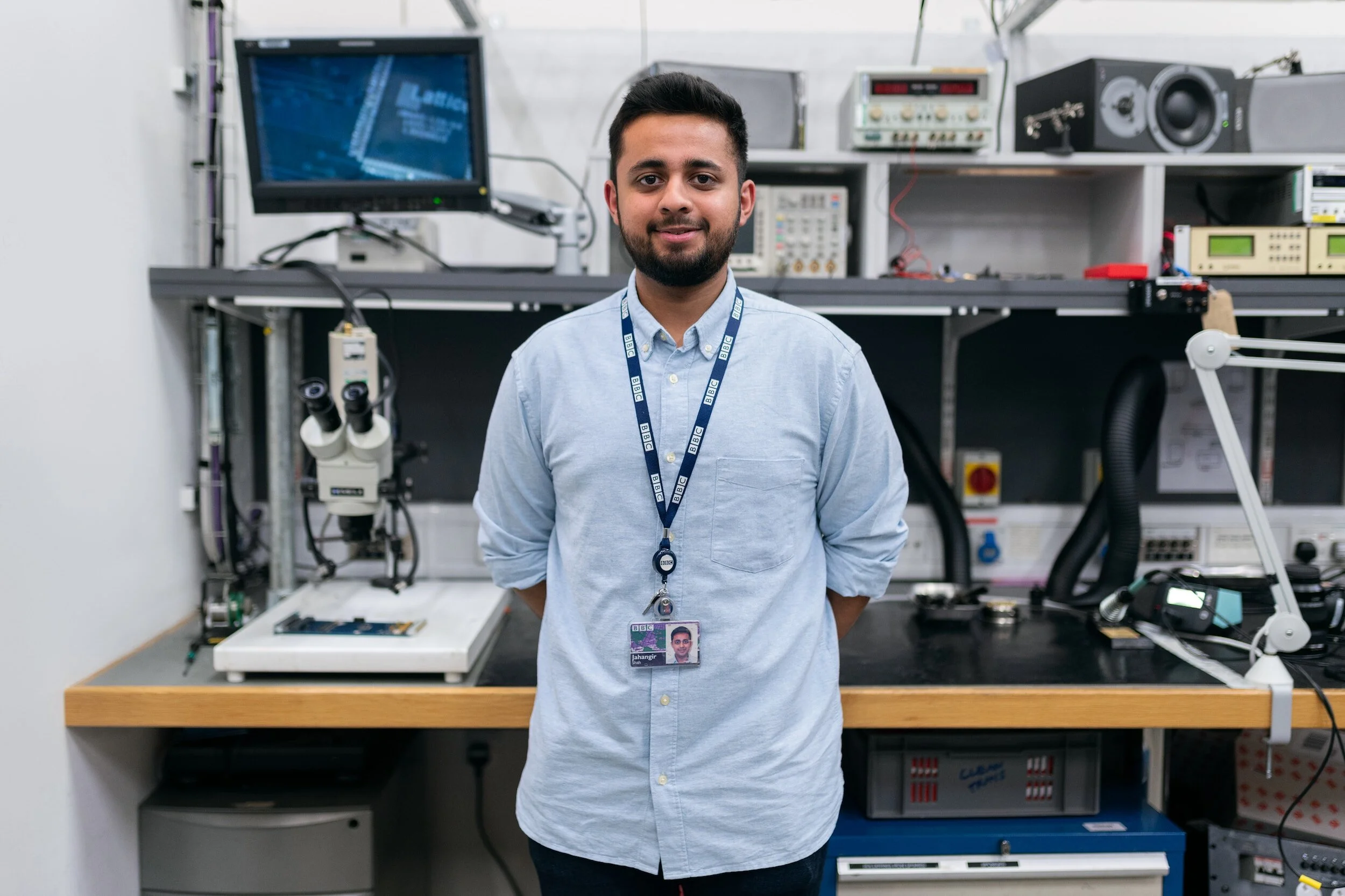 Engineer picture standing in front of computer desk.