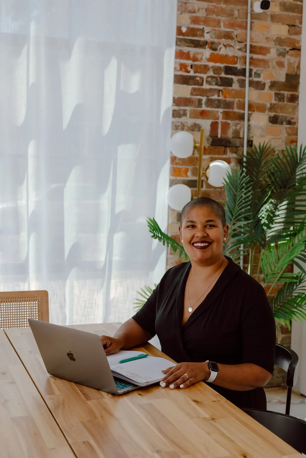Doula Kelli Blinn sitting at a table with a laptop.