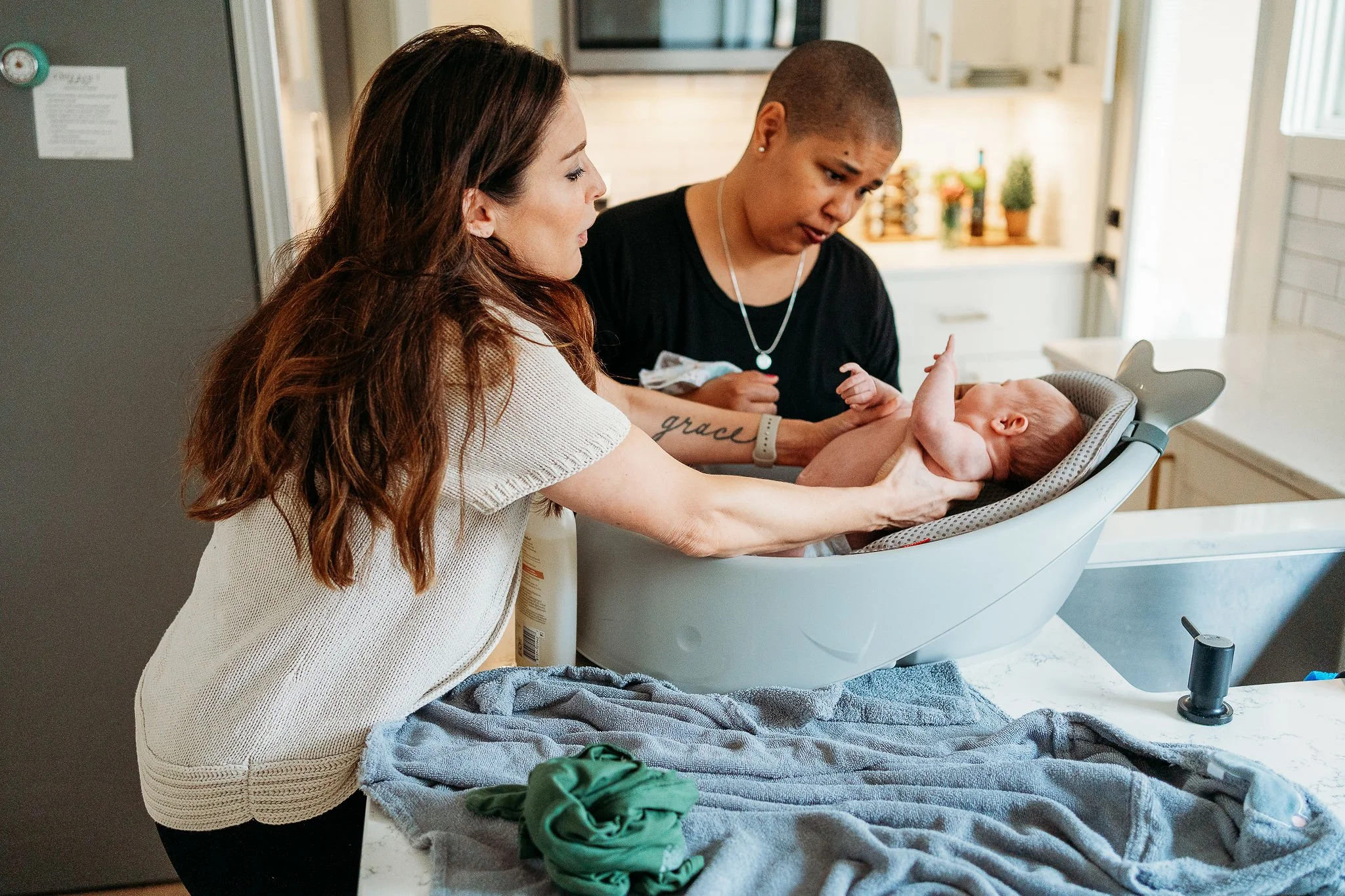 Doula Kelli Blinn assisting a new mom with an infant bath