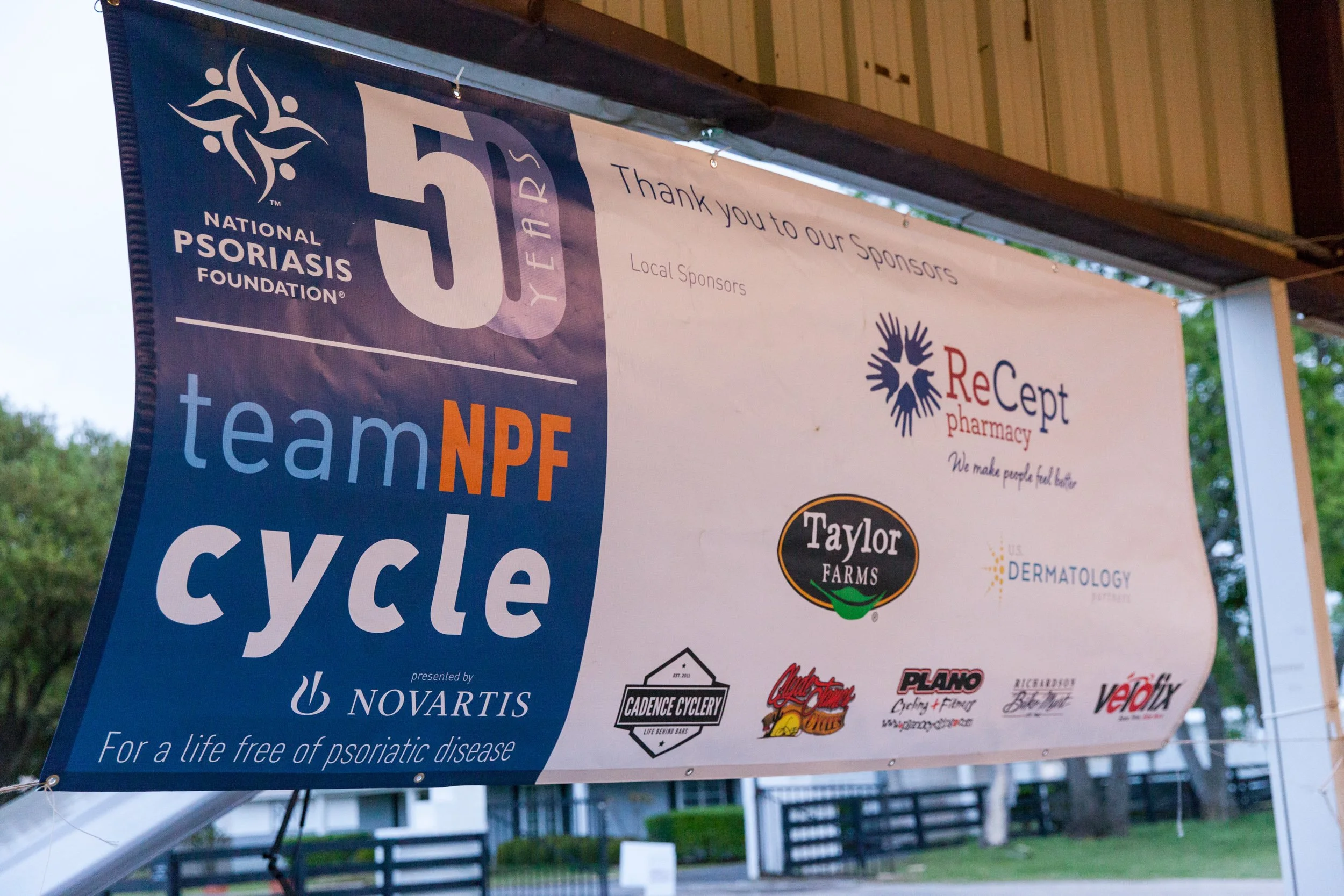 Sponsor signage and event branding displayed at a National Psoriasis Foundation cycling fundraiser in North Texas.