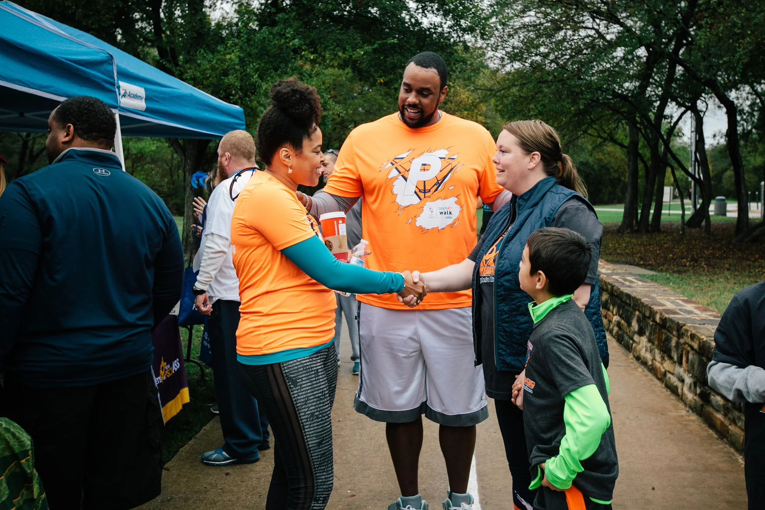 A warm interaction between event participants and volunteers captures the community connection behind a nonprofit fundraising event.