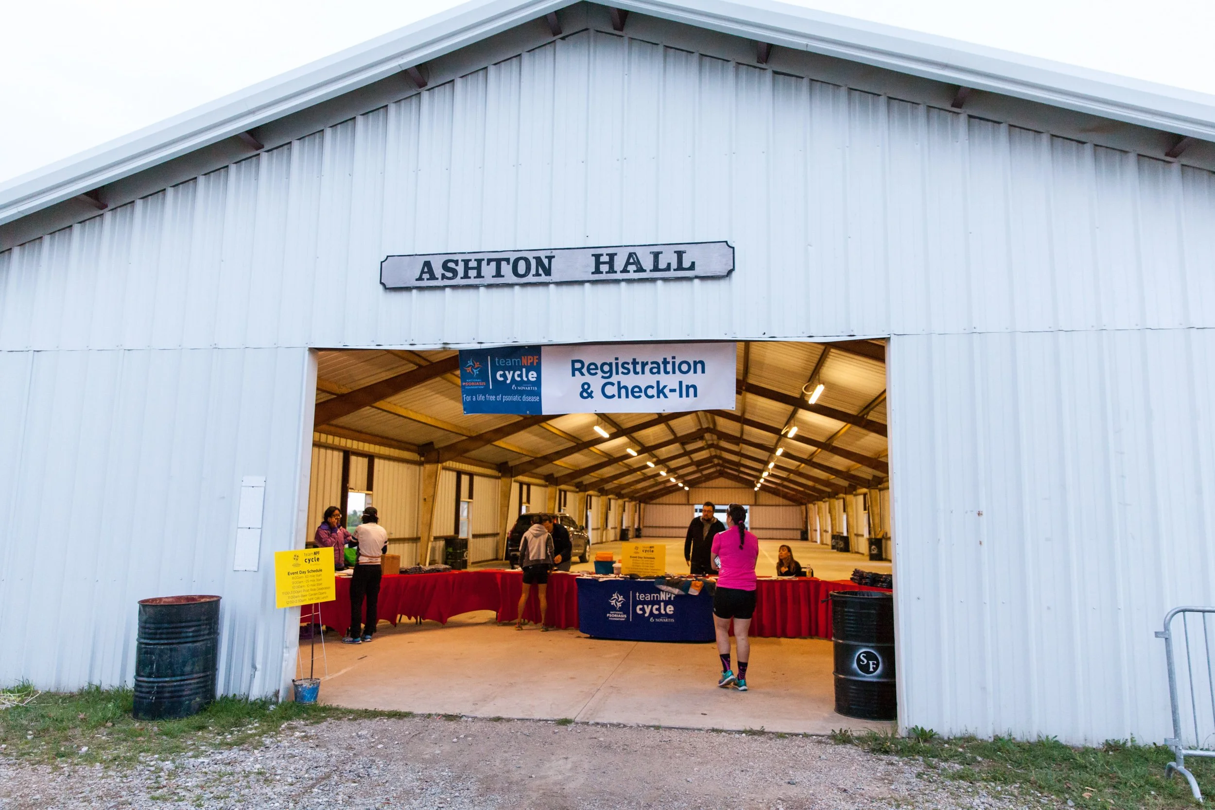 Participants check in at registration before a National Psoriasis Foundation cycling fundraiser, showing volunteers and event-day activity.