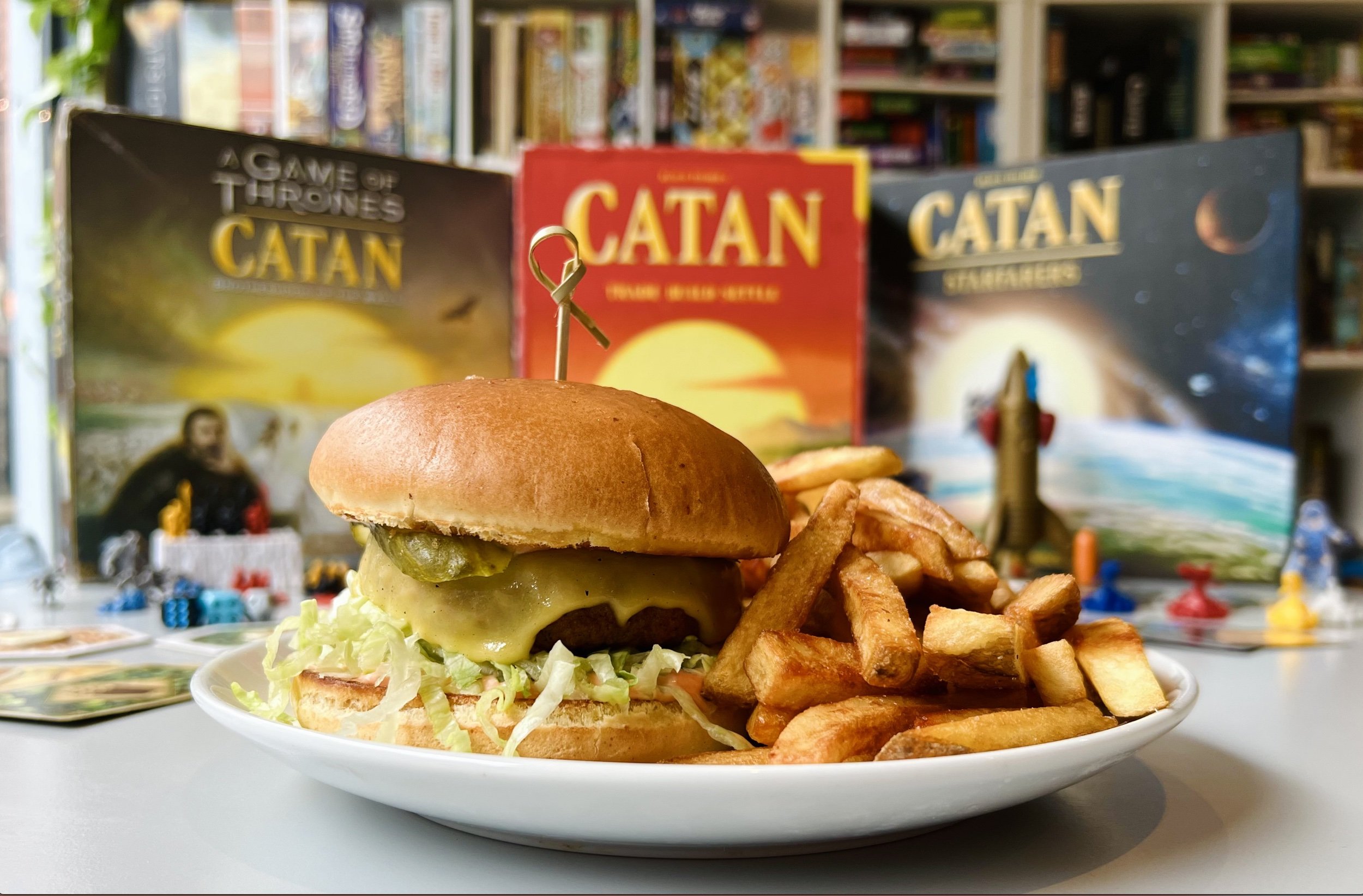 Vegan burger on table surrounded by board games at Norwich board games cafe Slice + Dice