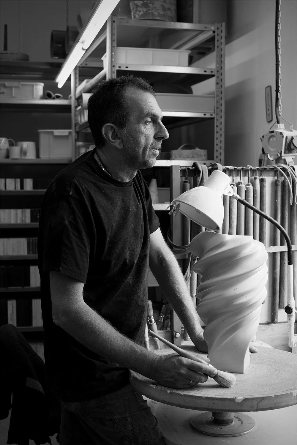 Man sculpting a ceramic piece in a workshop