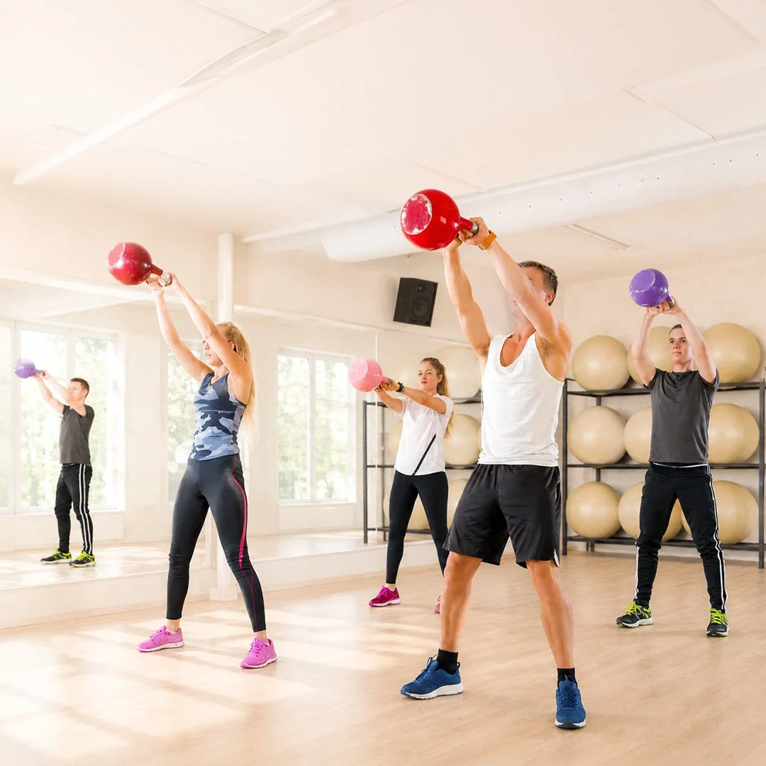 Group training session with men and women exercising with Kettlebells in a kettlercise workout class