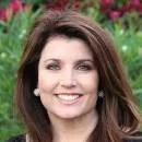 Smiling woman with brown hair against a natural background.