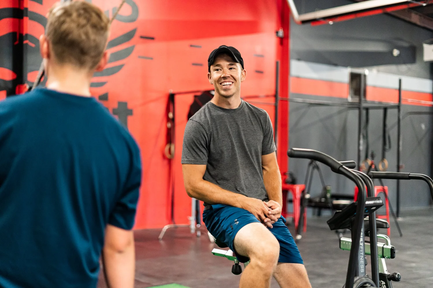 Smiling coach talking with an athlete in a Rebel Sports Performance branding shoot