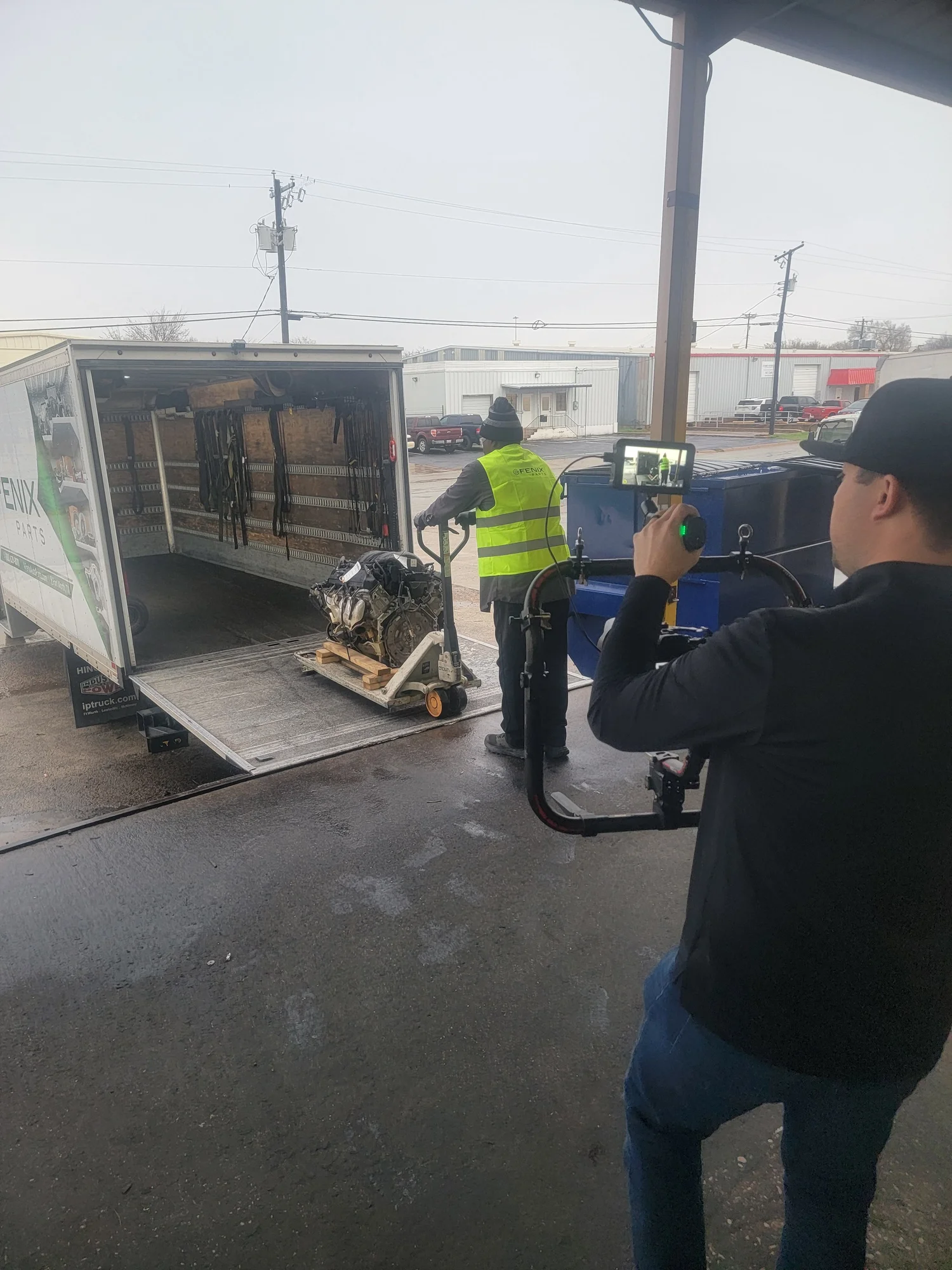 Videographer filming a worker loading a truck on a Hummingbird Media Productions shoot