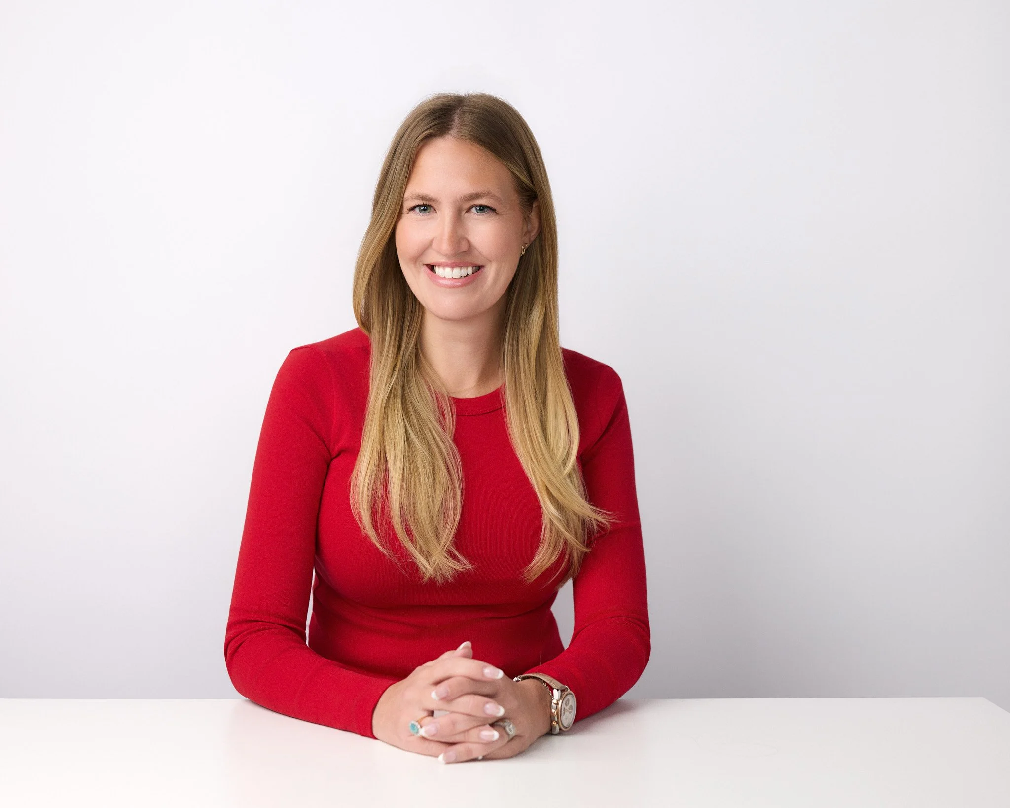 Professional headshot in Irvine of a realtor. Clean look with white background and desk