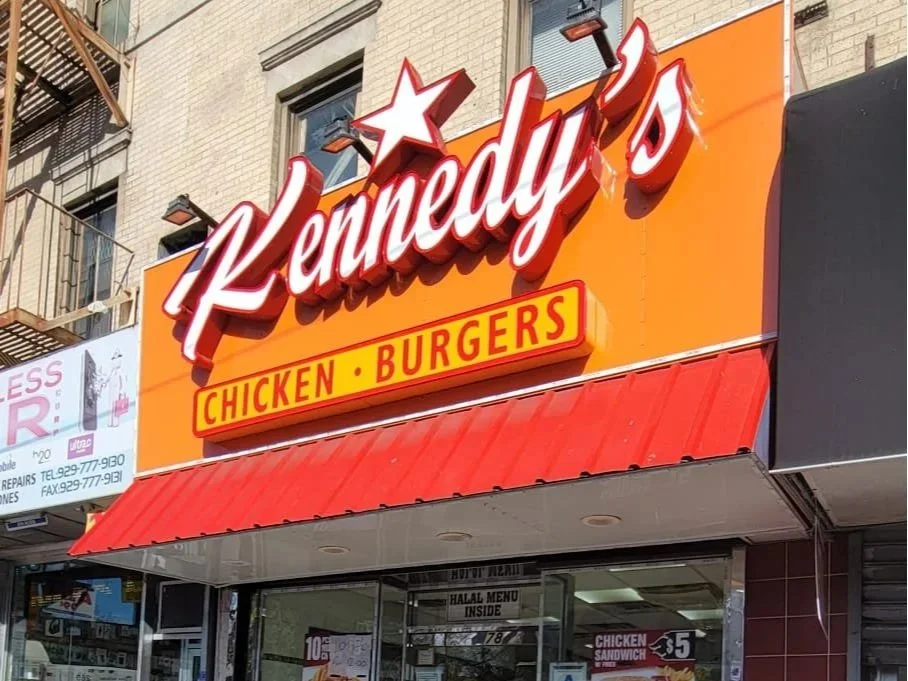 Image of Kennedy’s Chicken & Burgers store front in the Bronx, New York with two bikes outside.