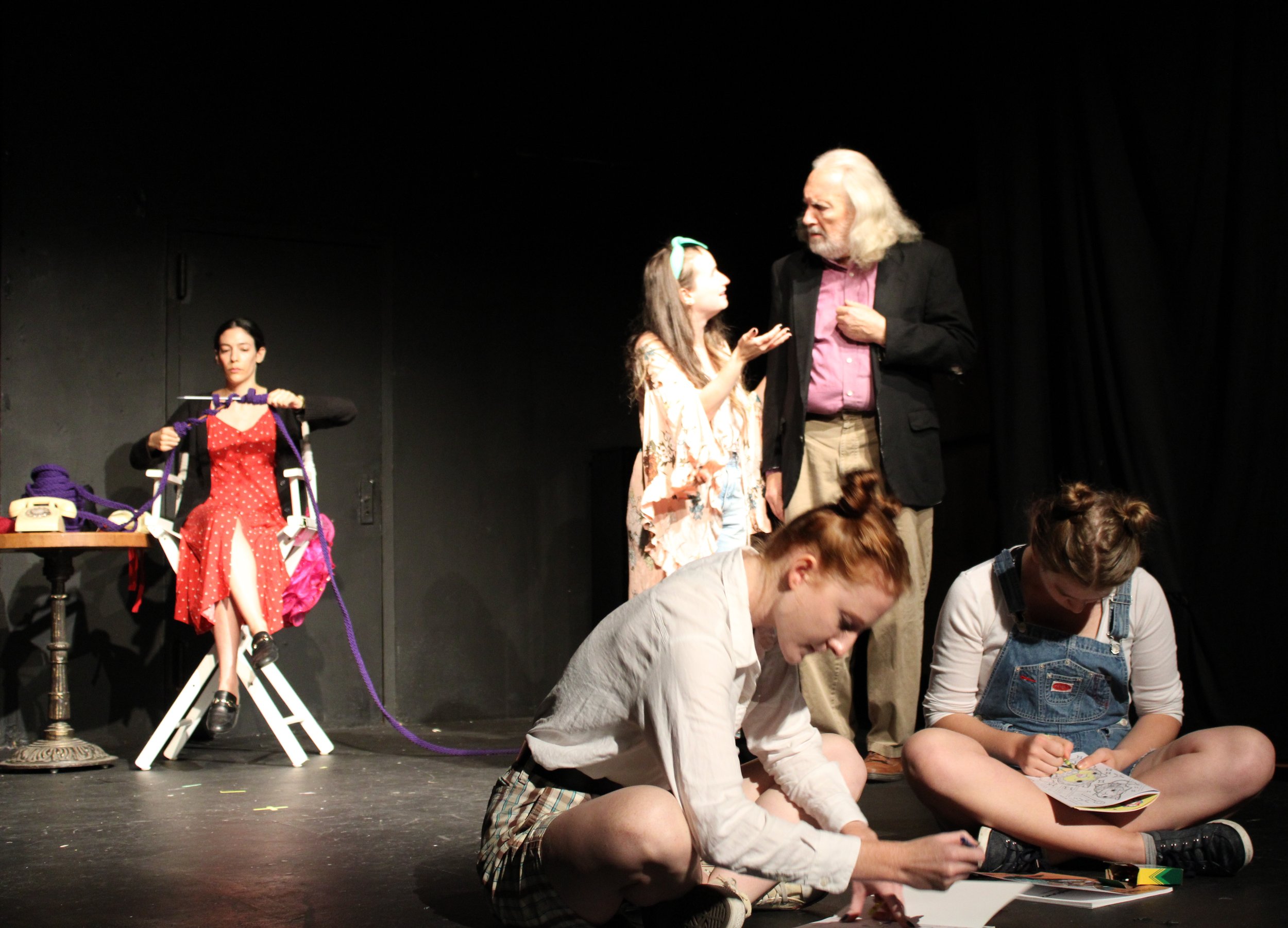 Chris (Rachel Halper) enlightens Six (Mark Peters), while the kids (JaneAnne Halter and Clara Steeves) play in the foreground and Madame Lafarge (Teena Klein) knits destiny in the background.