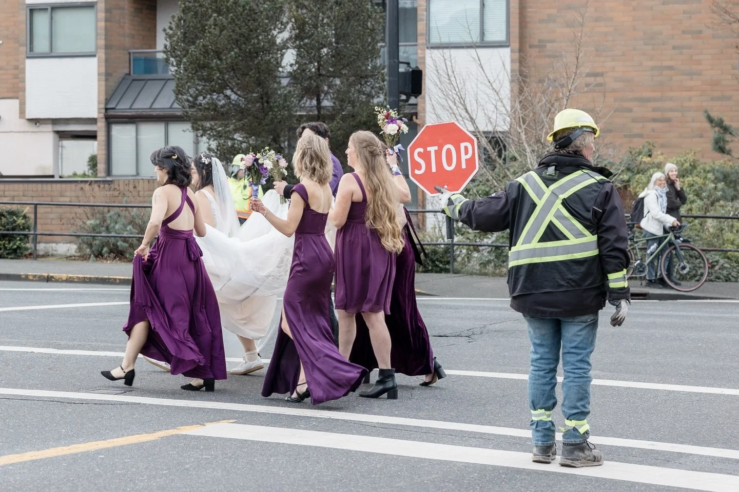 Not every wedding party gets a personal traffic escort &mdash; but Genevieve + Harpreet&rsquo;s crew made it work. Purple dresses, sharp suits, and one very accommodating road worker. Victoria doing what Victoria does. #westcoastwedding #bcweddingpho