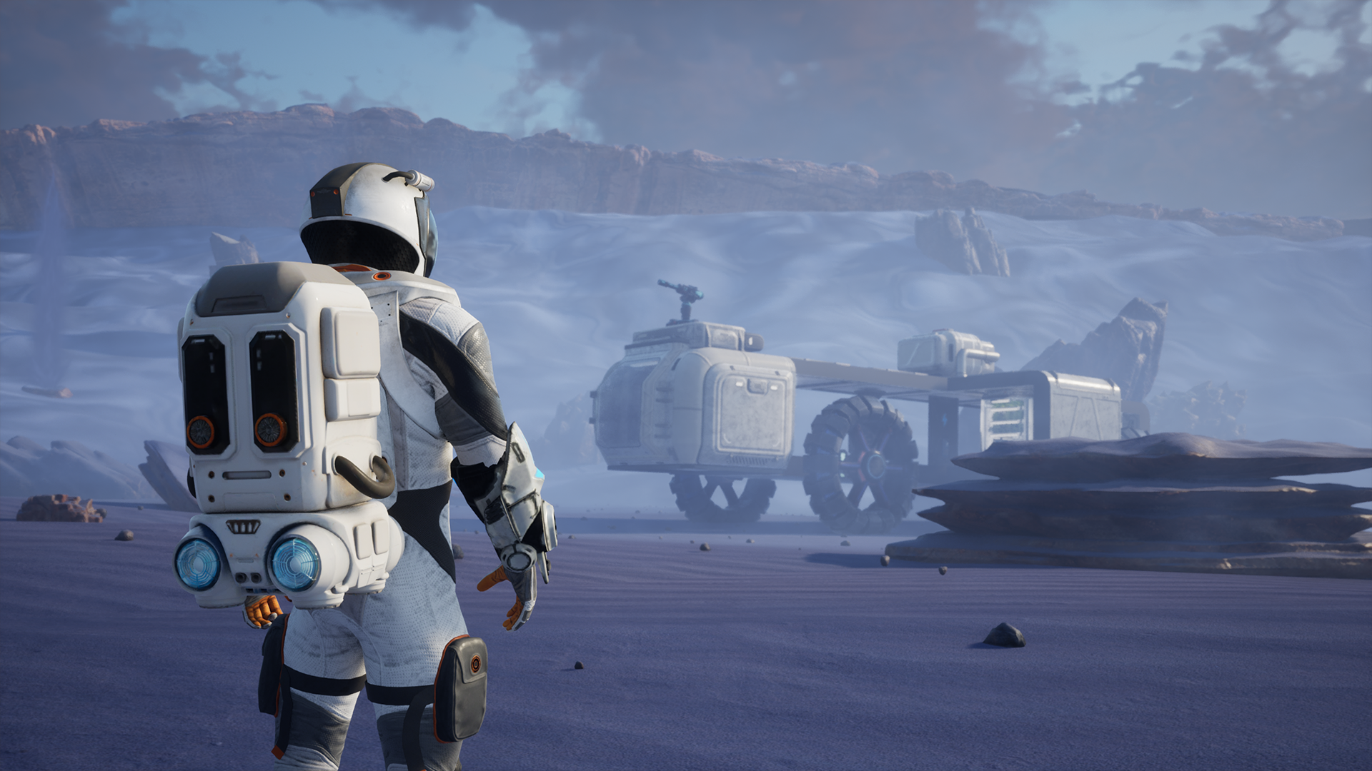 An astronaut in a spacesuit standing on a mountainous, icy alien landscape with futuristic vehicles and structures in the background.