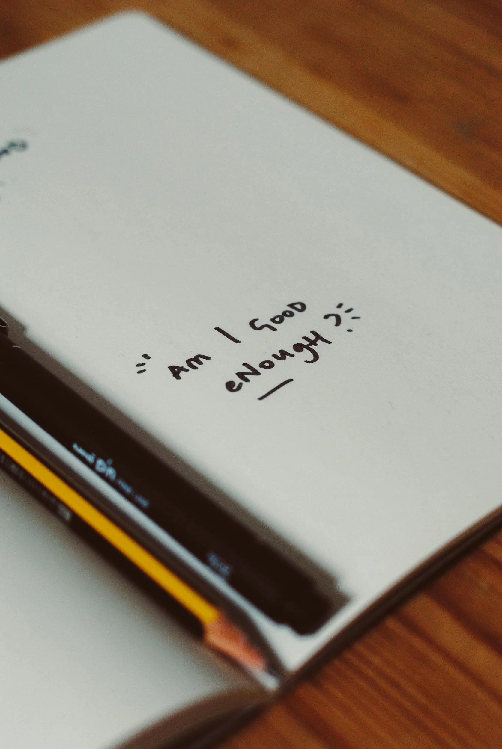 Open notebook with the question am I good enough representing relationship self doubt and psychological patterns