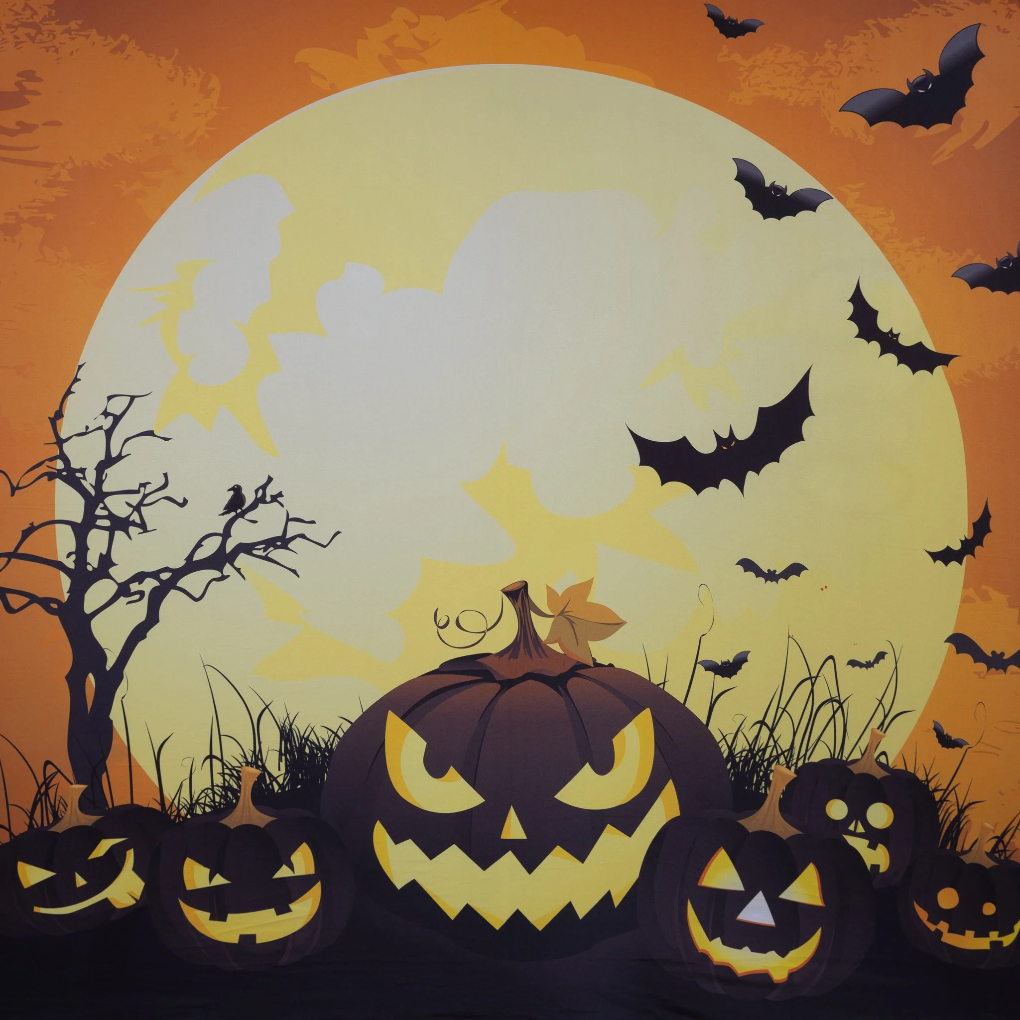 A Halloween scene with a large, sinister carved pumpkin with glowing eyes and mouth, surrounded by smaller pumpkins with carved faces, a leaf on top, and a barren tree, all set against a full moon and a sky filled with flying bats.
