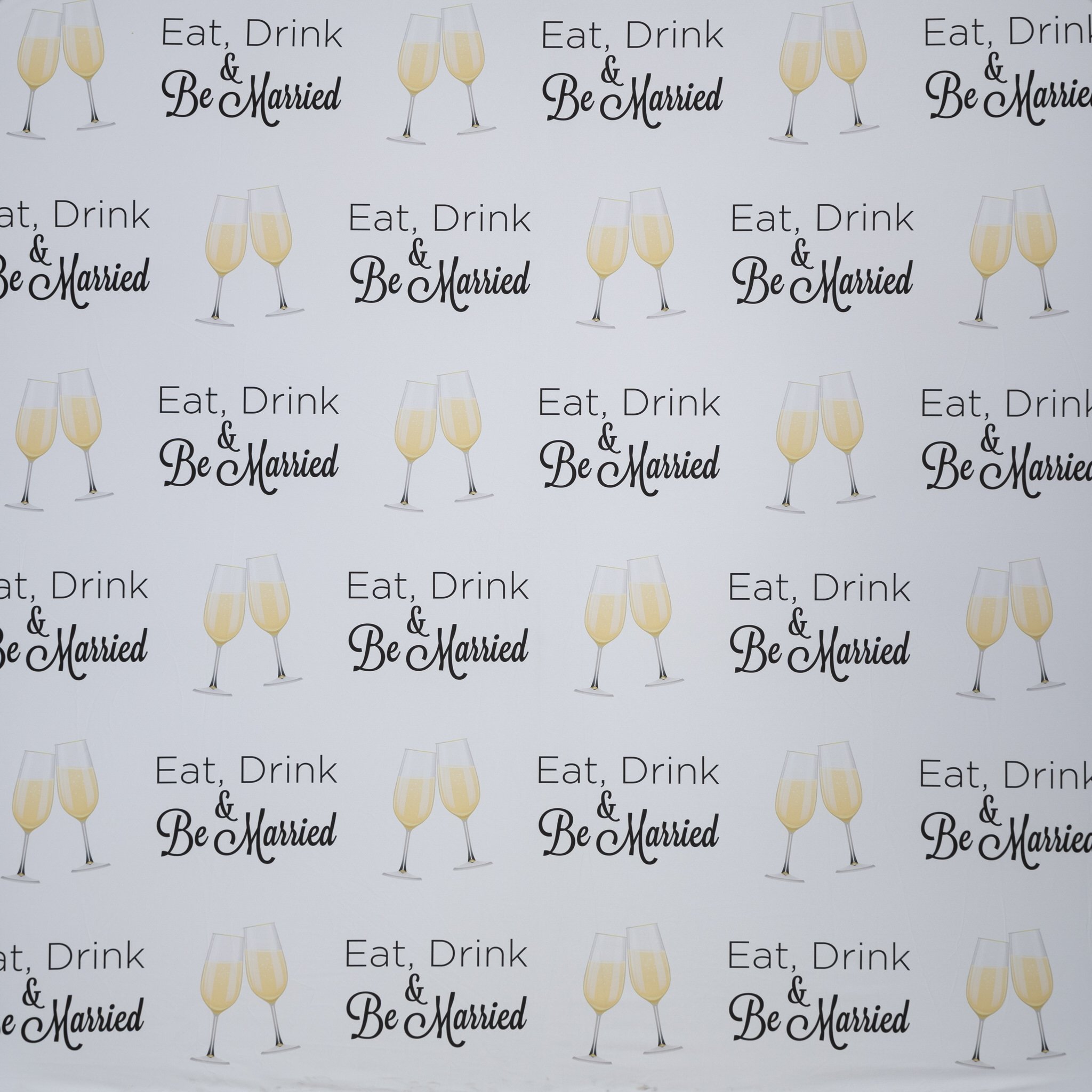 A repeating pattern of text and images. The text says 'Eat, Drink & Be Married' in black, with a pair of champagne glasses filled with a yellow bubbly liquid next to the text.