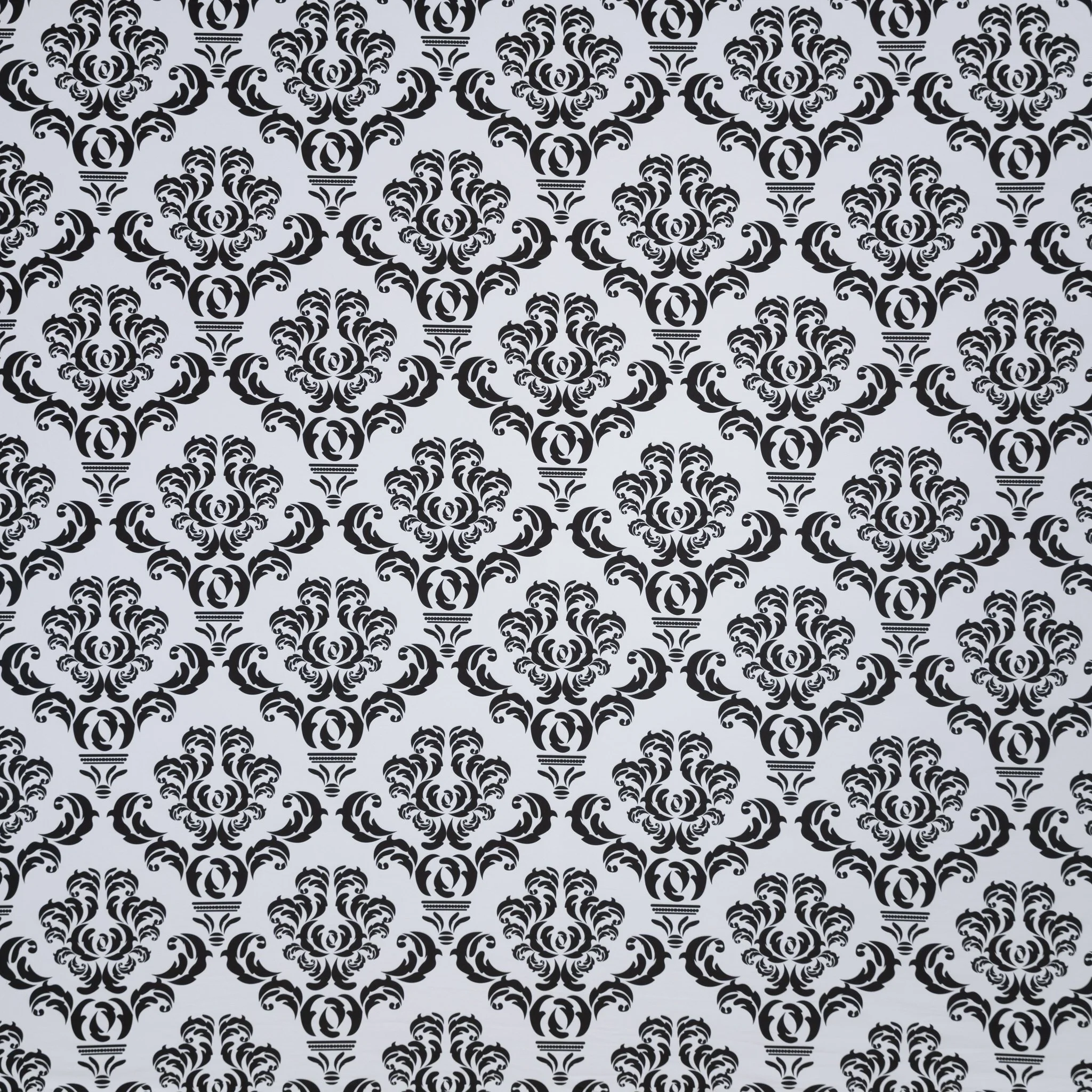 Repeating black floral damask pattern on a white background.