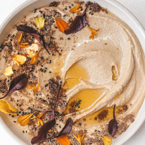 Chef Claire’s peanut butter hummus topped with olive oil, black sesame seeds, edible flowers + micro herbs