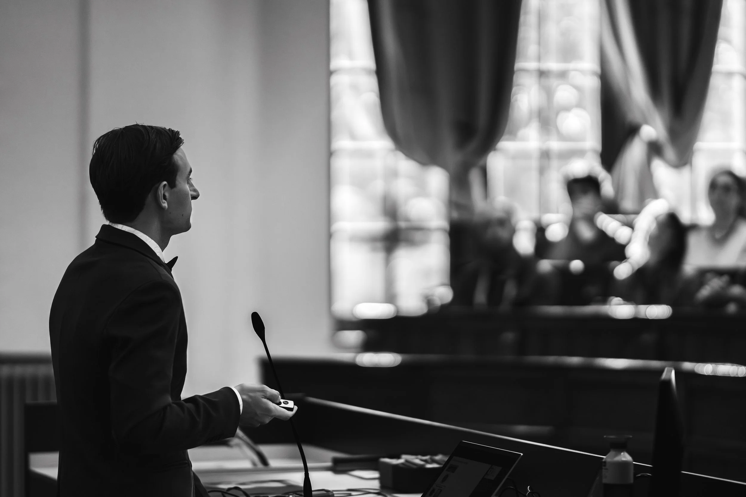 PhD candidate standing in front of crowd, presenting his thesis