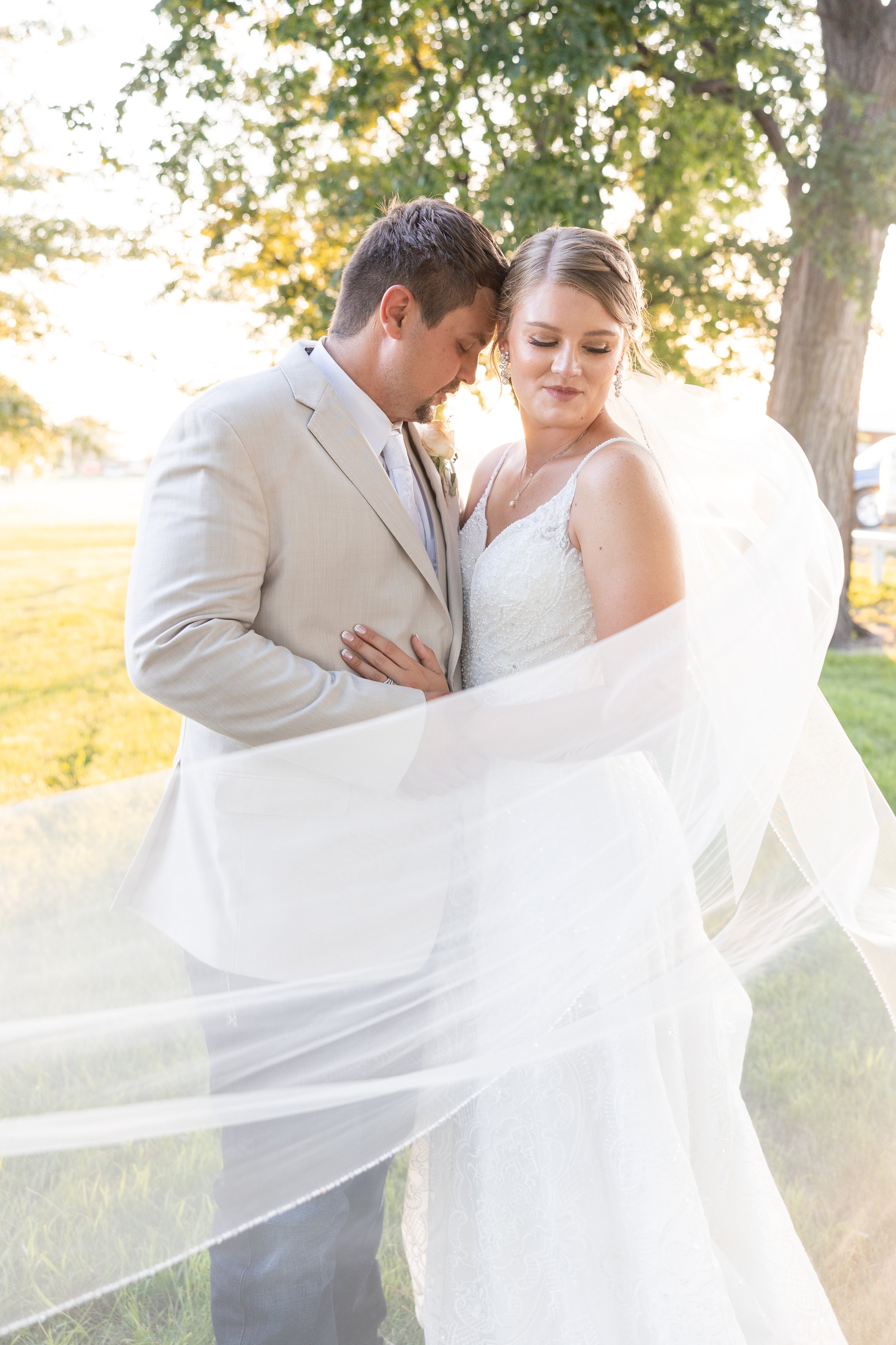 Bride and groom with long flowing veil on their wedding day