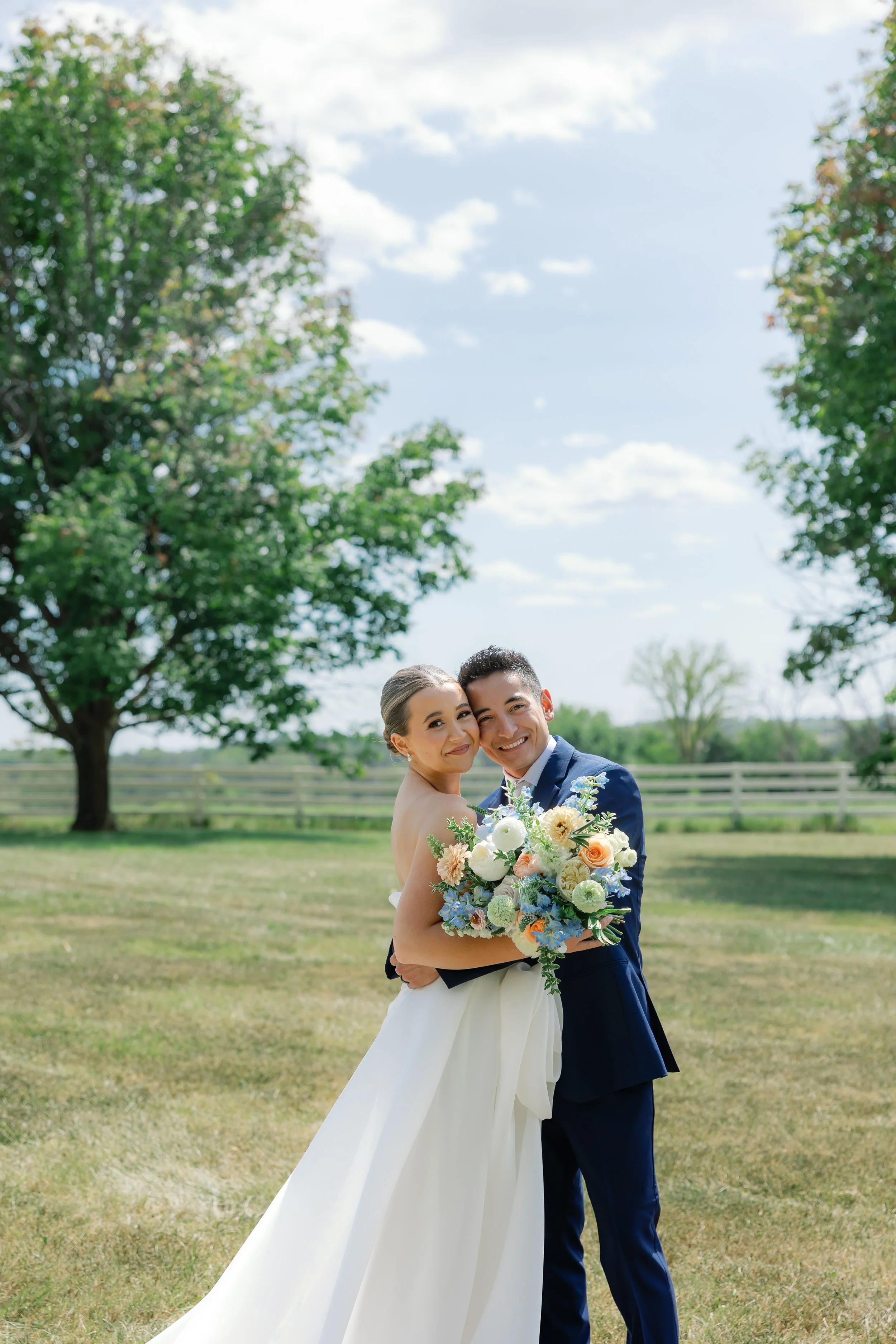 Callie and Austin share a quiet moment surrounded by soft summer light, their pastel blue and peach florals adding a romantic touch to their elegant Missouri wedding.