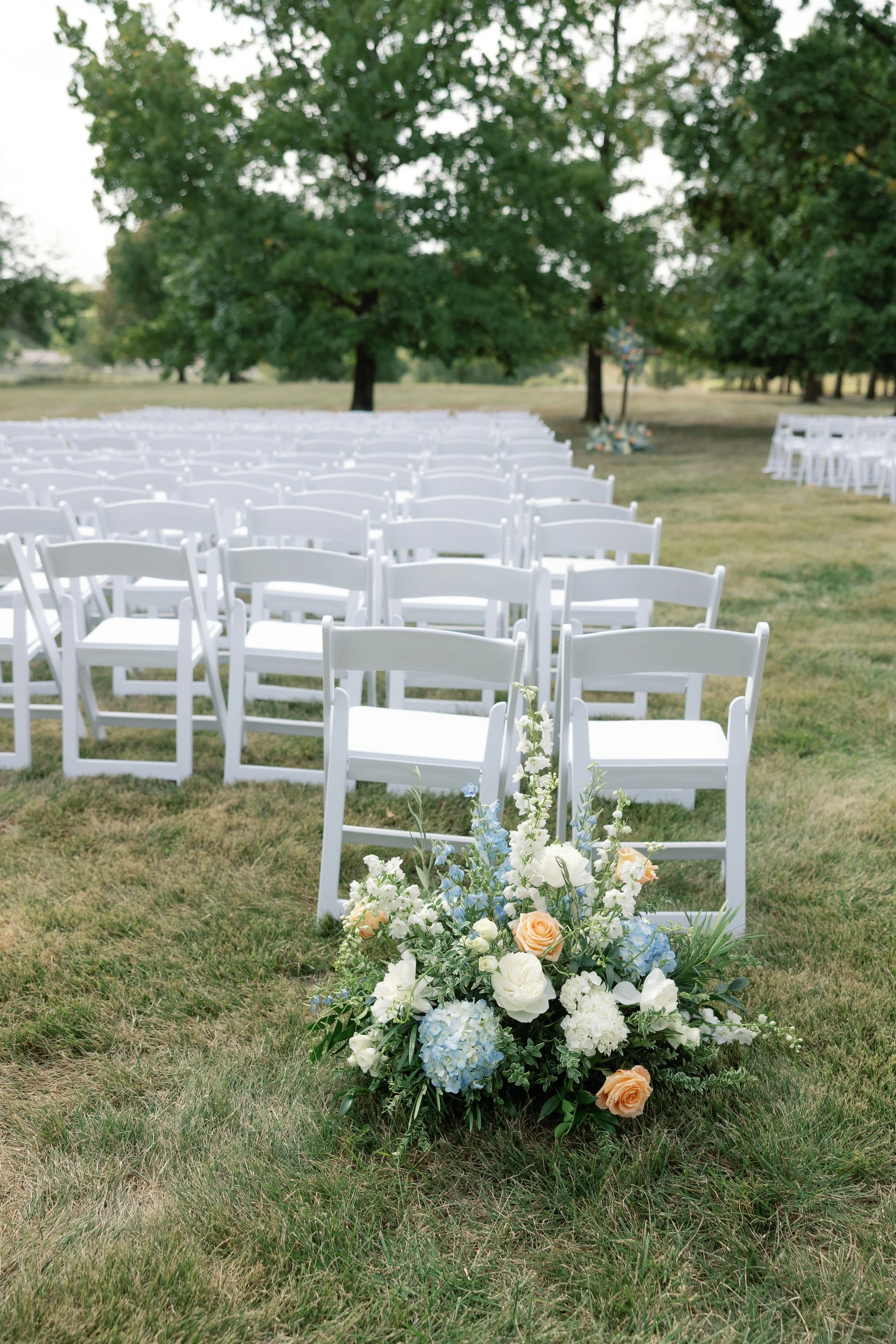 Pastel floral aisle arrangements designed for an elegant outdoor Missouri wedding.