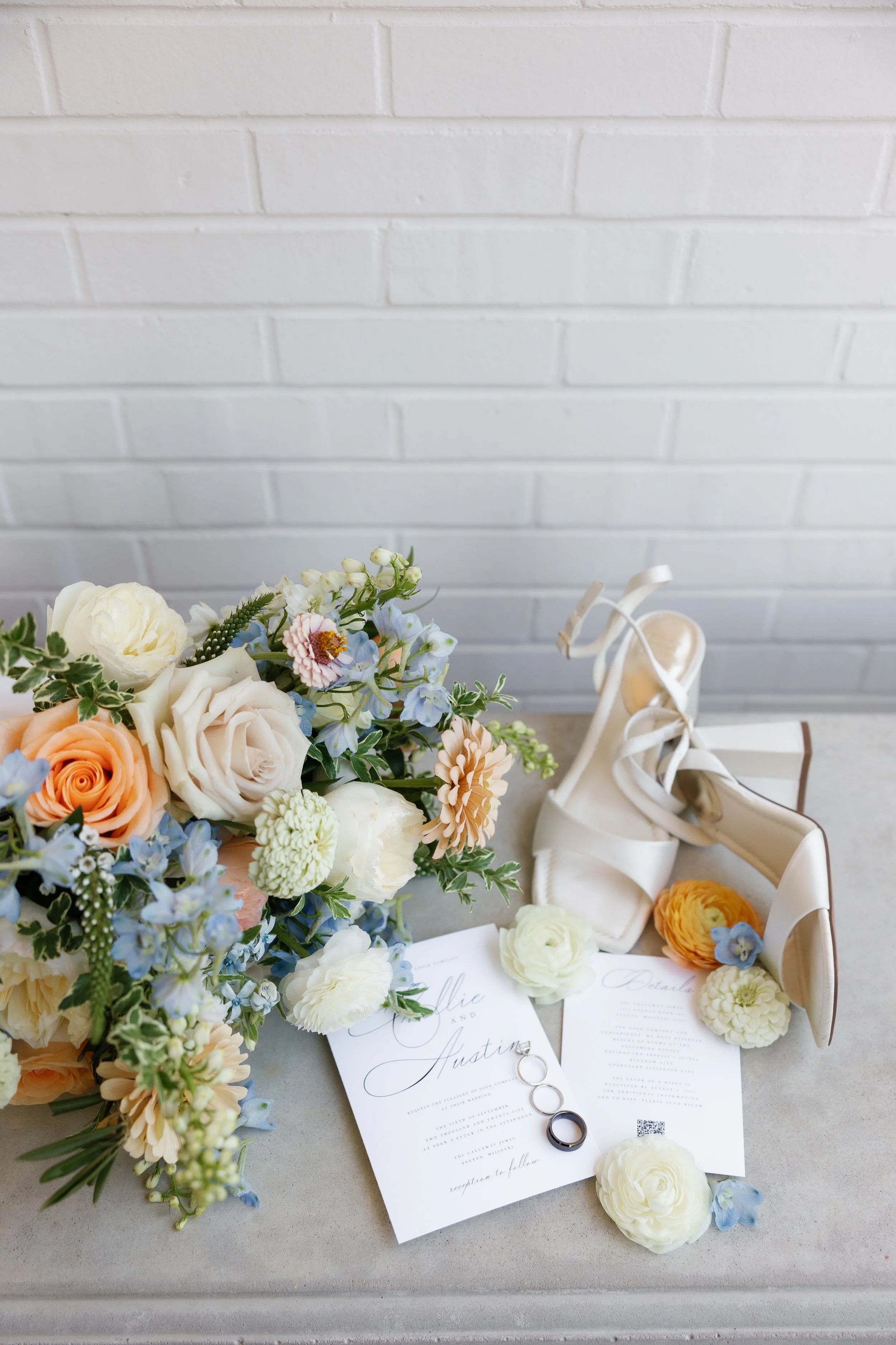 Wedding invitation suite surrounded by delicate blue and white blooms for a cohesive pastel aesthetic.