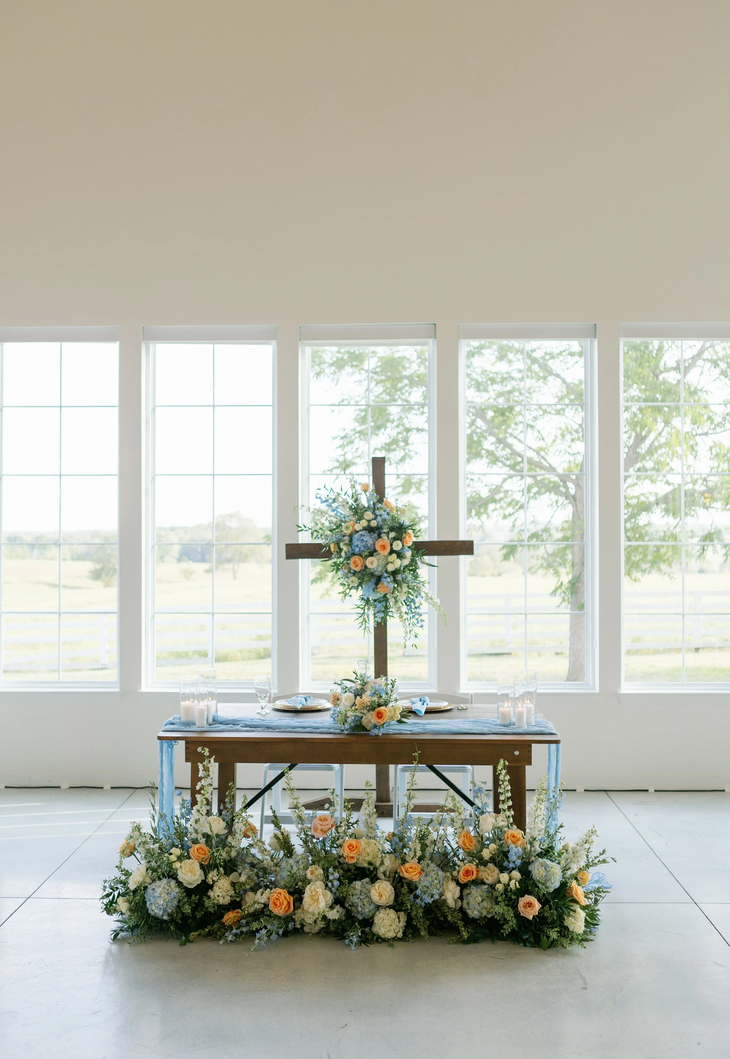 Callie and Austin's head table framed by soft, garden-style florals that bring color and movement to the reception space. Perfect inspiration for couples wanting romantic Missouri wedding décor.