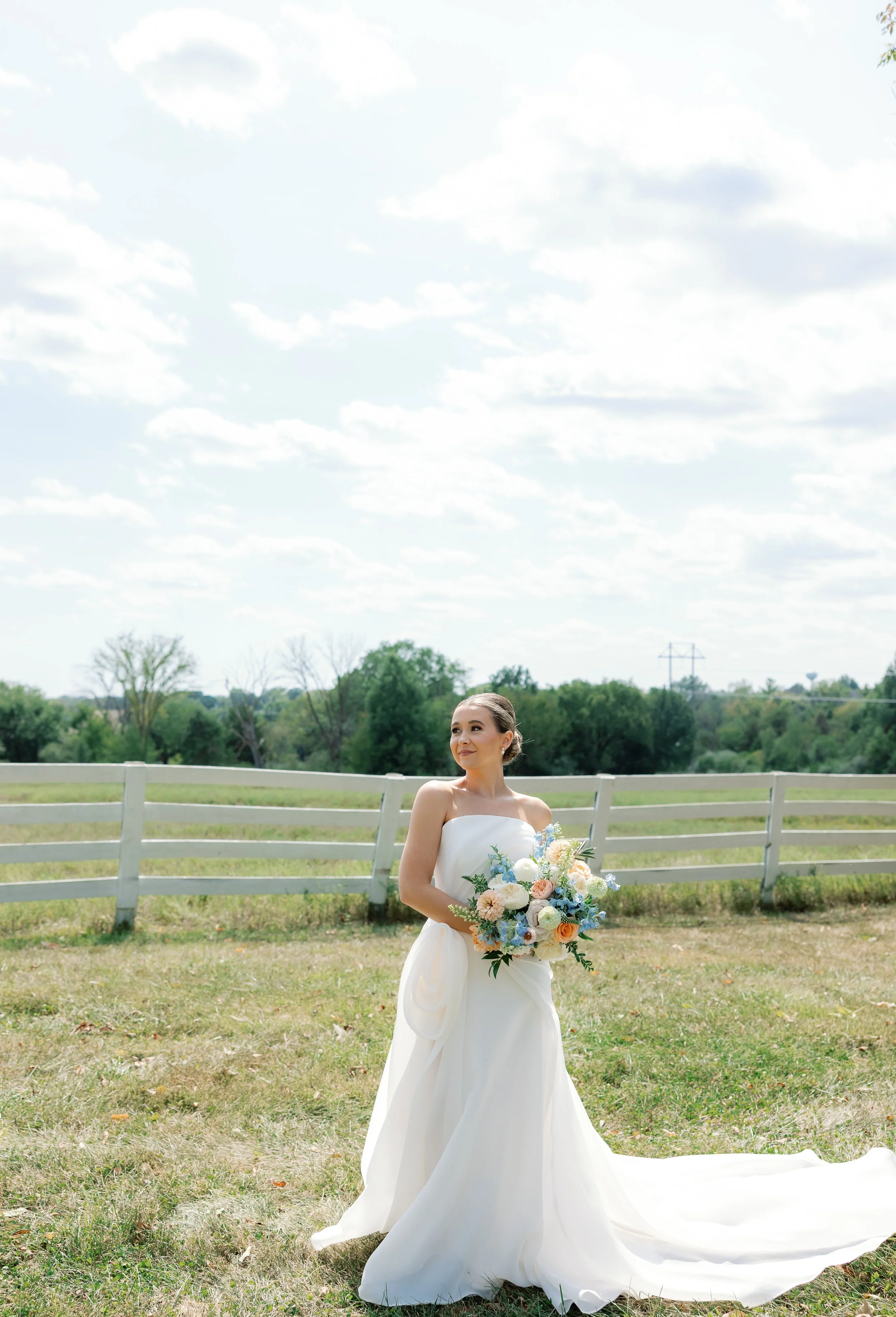 Bride Callie standing in natural light with her pastel bouquet, captured beautifully by Jennifer Wahlbrink Photography.