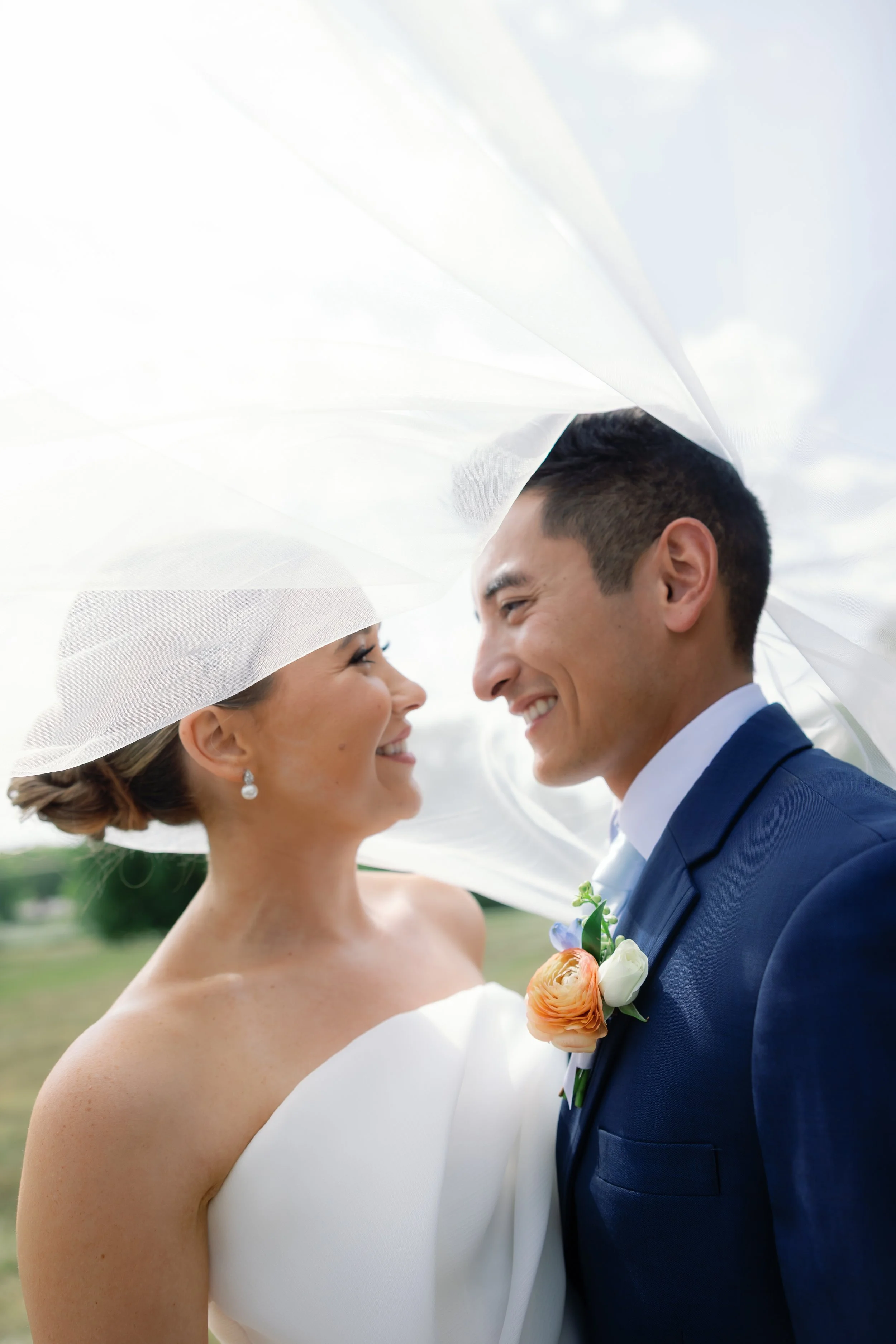 Callie and Austin captured in an airy, natural moment that highlights the soft color palette and refined floral styling of their summer wedding.