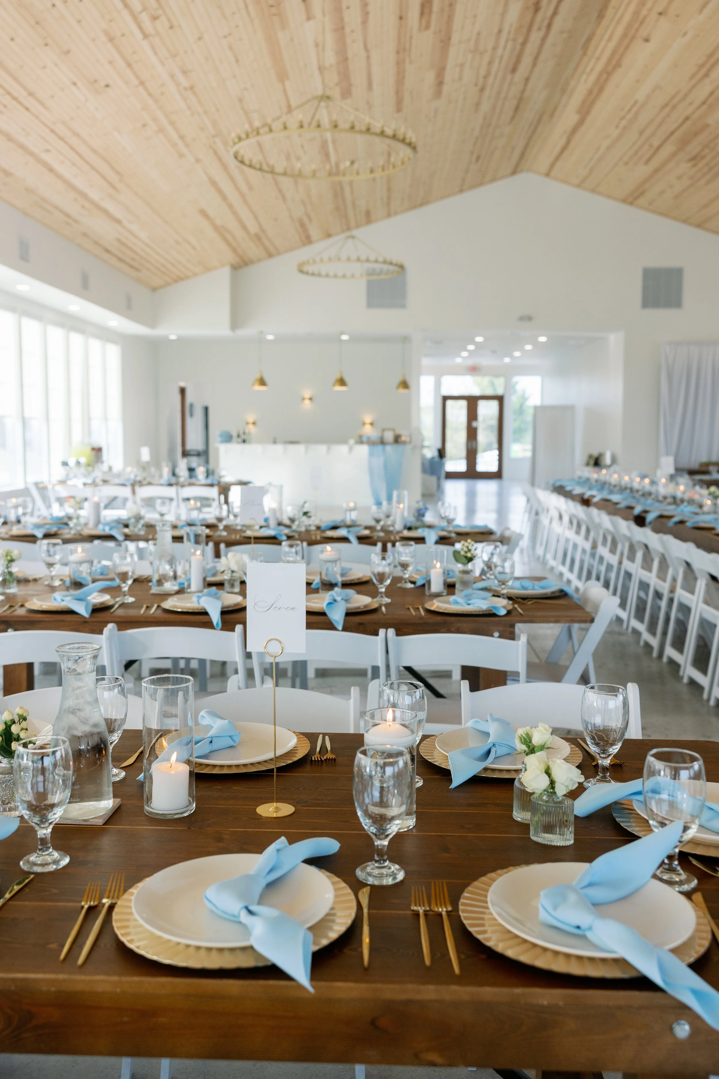 Romantic indoor reception floral centerpieces in soft pastel blue, white, and peach at The Callaway Jewel.