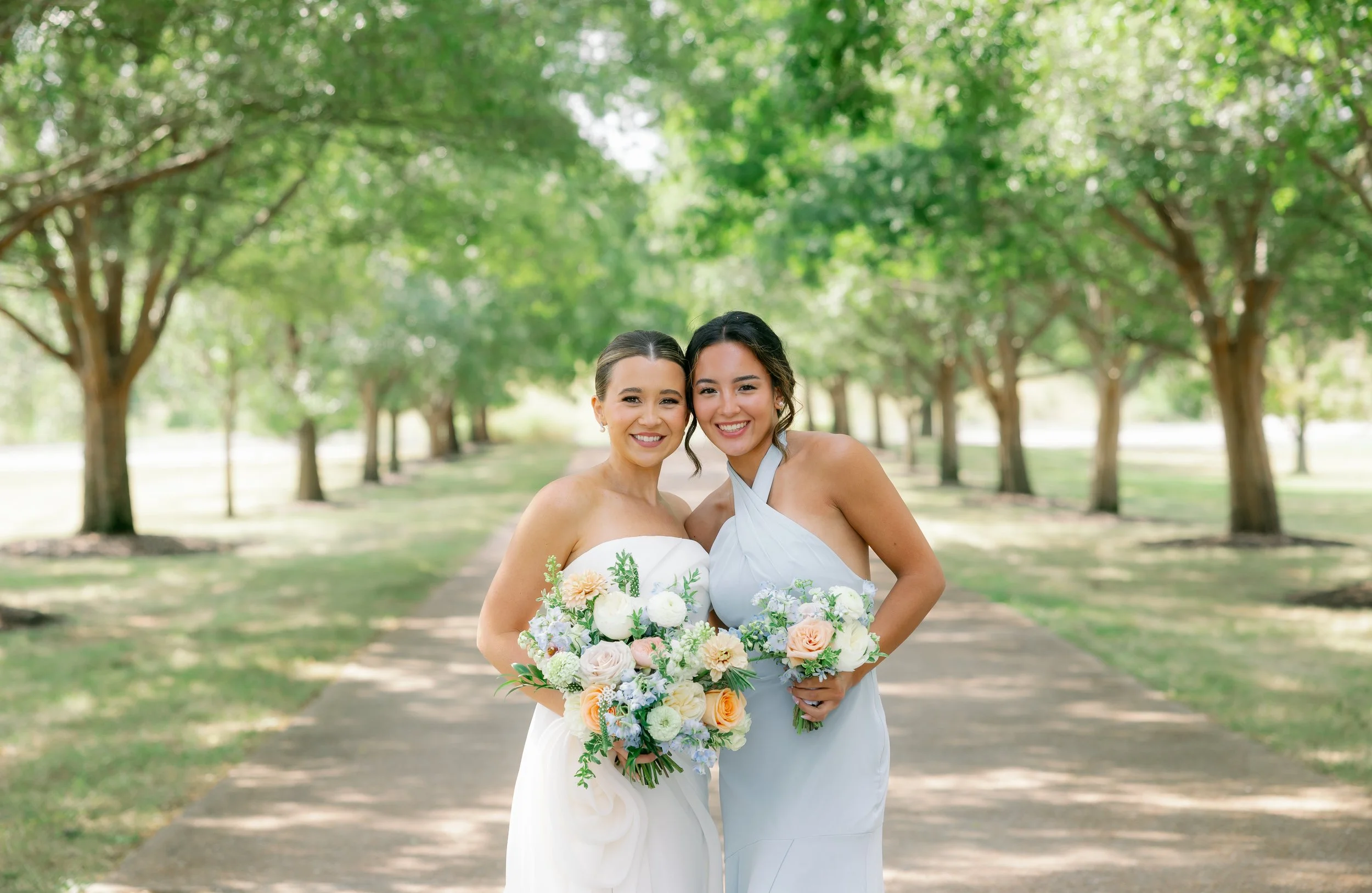 Pastel bridesmaid bouquets in soft blue, white, and peach carried during Callie & Austin’s Missouri summer wedding.