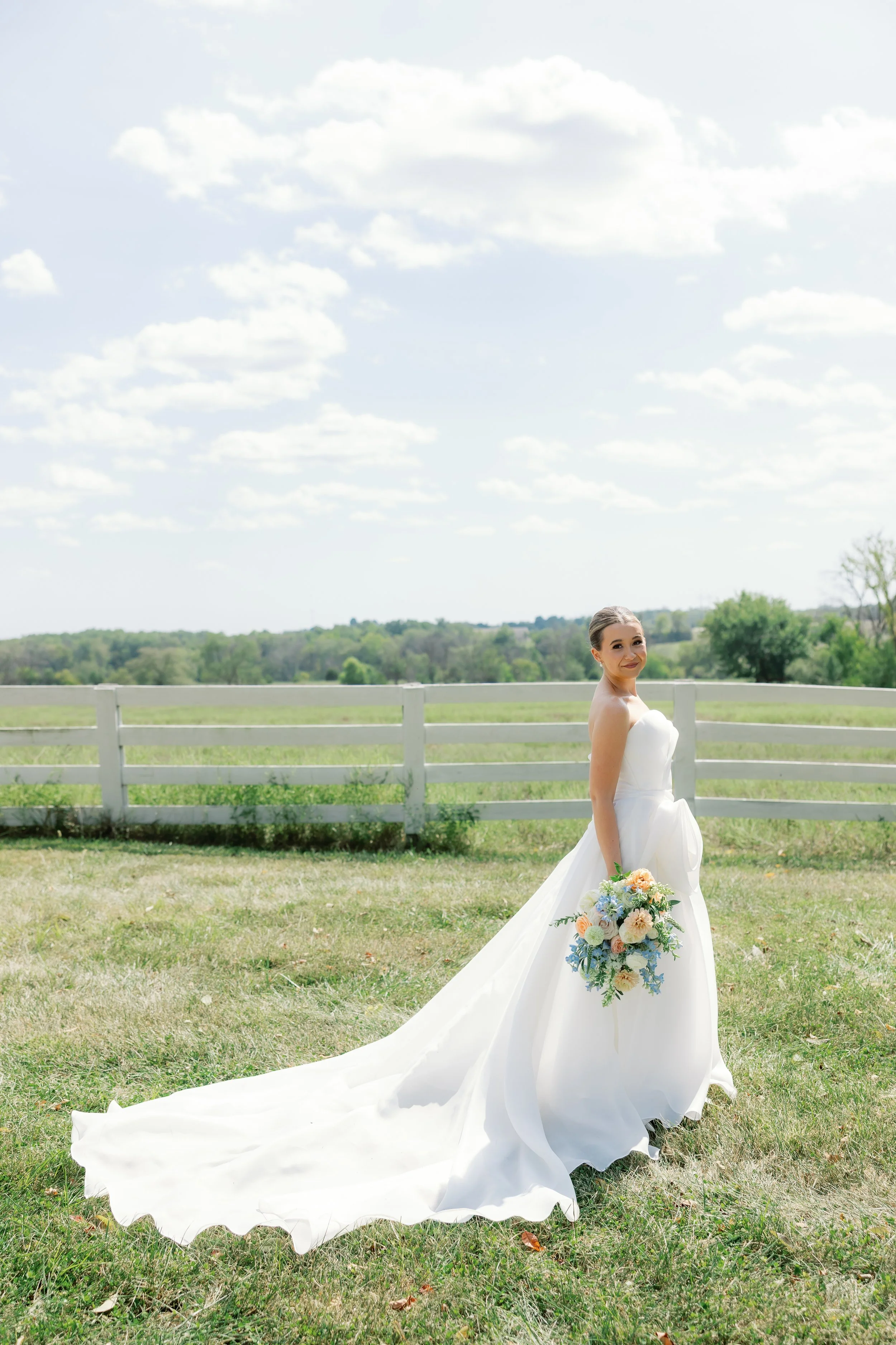 Former Miss Missouri Callie holding her romantic pastel bridal bouquet with airy summer florals and soft blue accents.