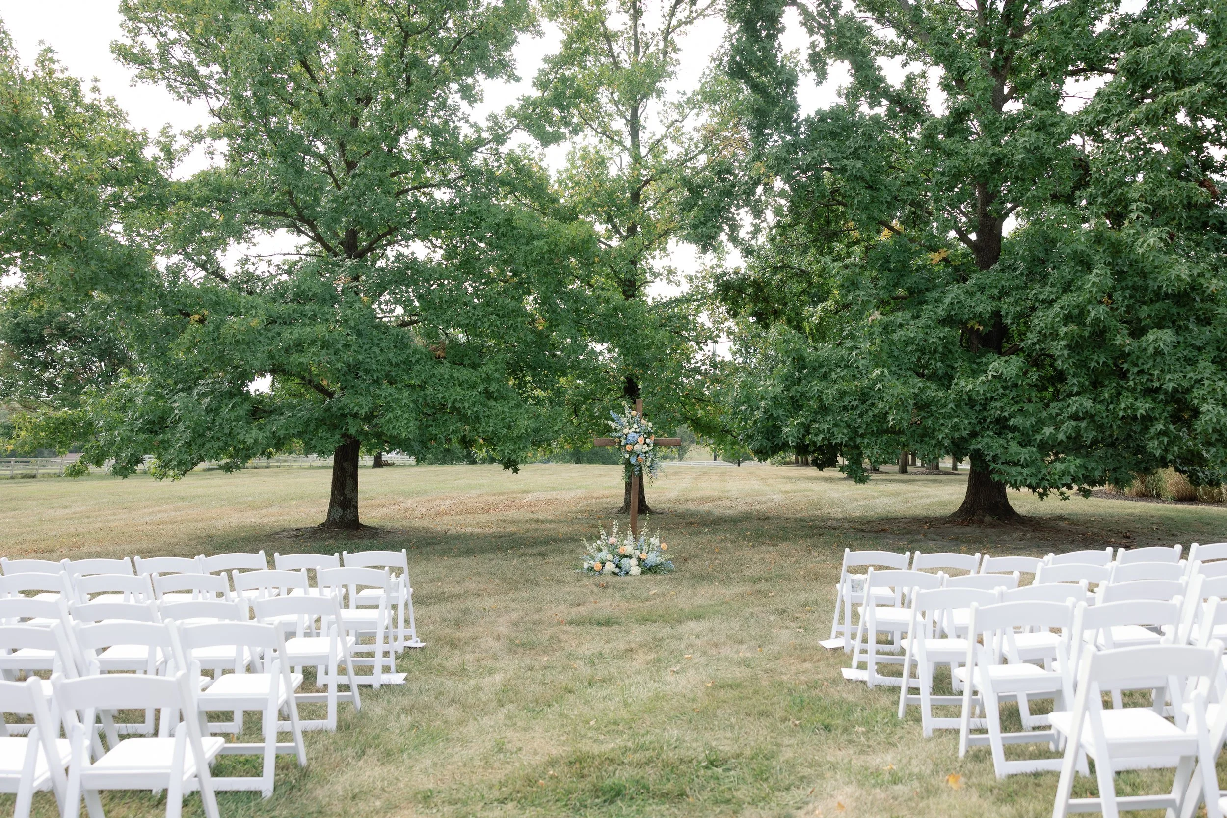 Outdoor ceremony floral arrangements in pastel blue, white, and peach at The Callaway Jewel in Fulton, Missouri.