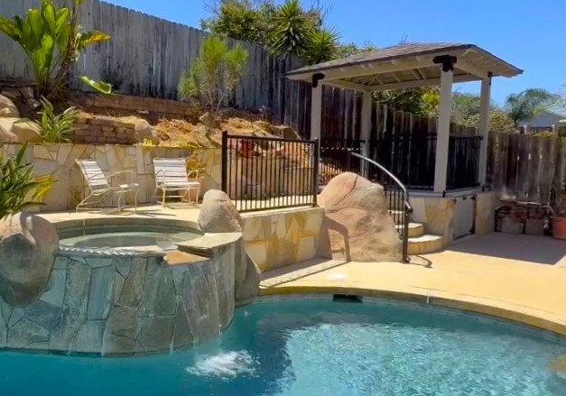 Custom backyard gazebo with black metal railing in San Diego, CA