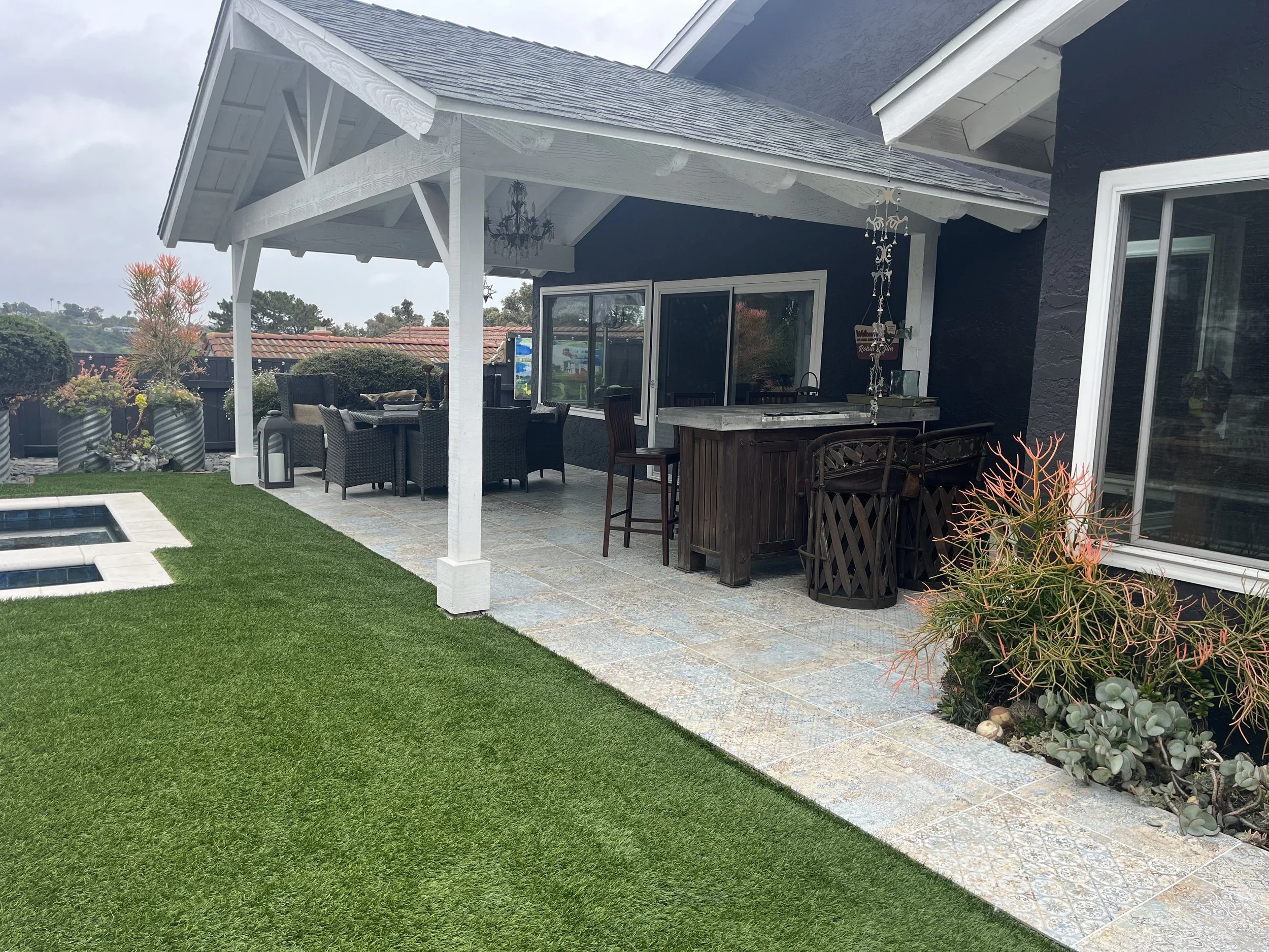 Custom outdoor living space with exterior tile,artificial turf and patio cover in Oceanside, CA.
